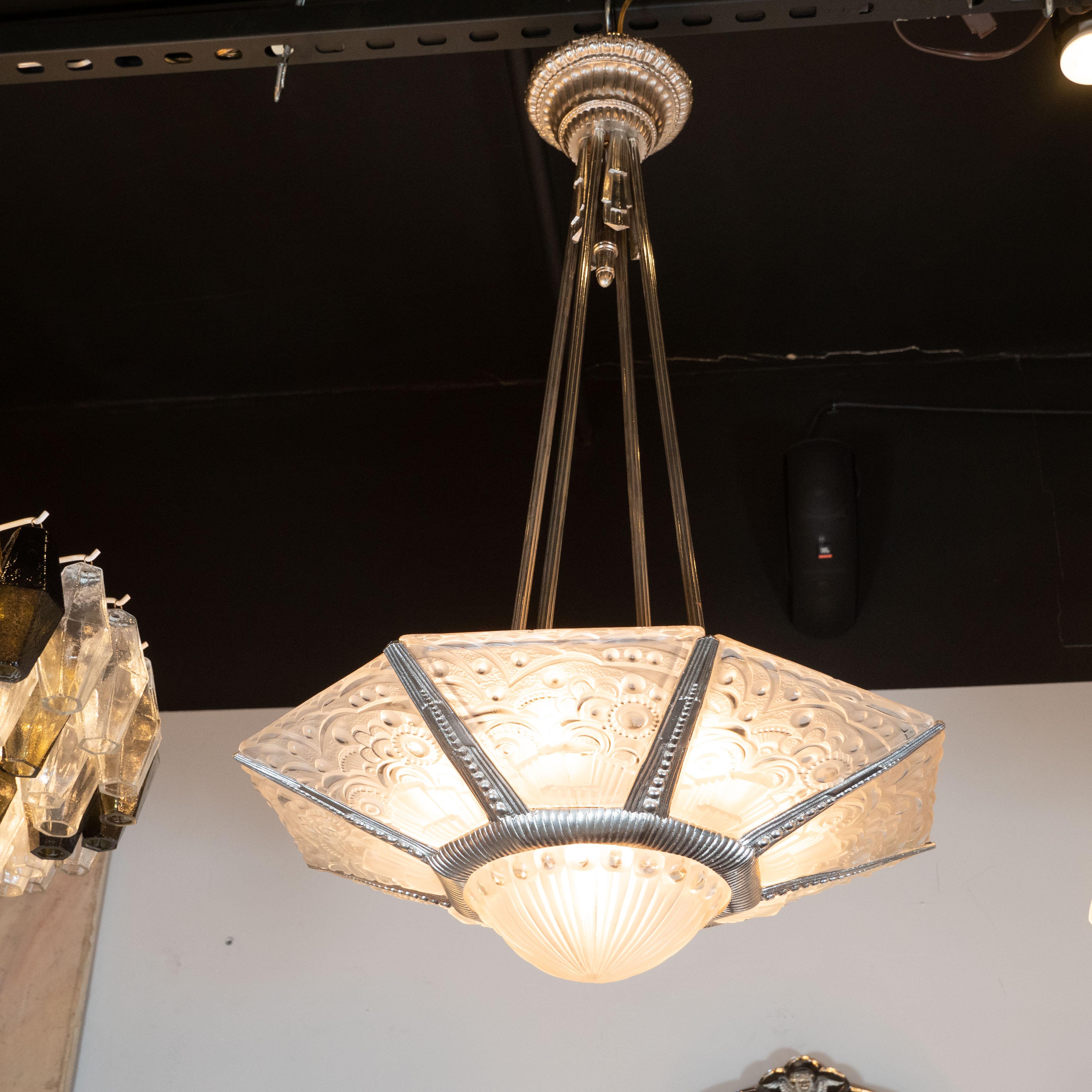 This stunning high style Art Deco skyscraper style chandelier was realized by the esteemed atelier of Georges Leleu in France circa 1930. It features a convex striated bottom shade that connects to an octagonal frame with similar channel detailing.