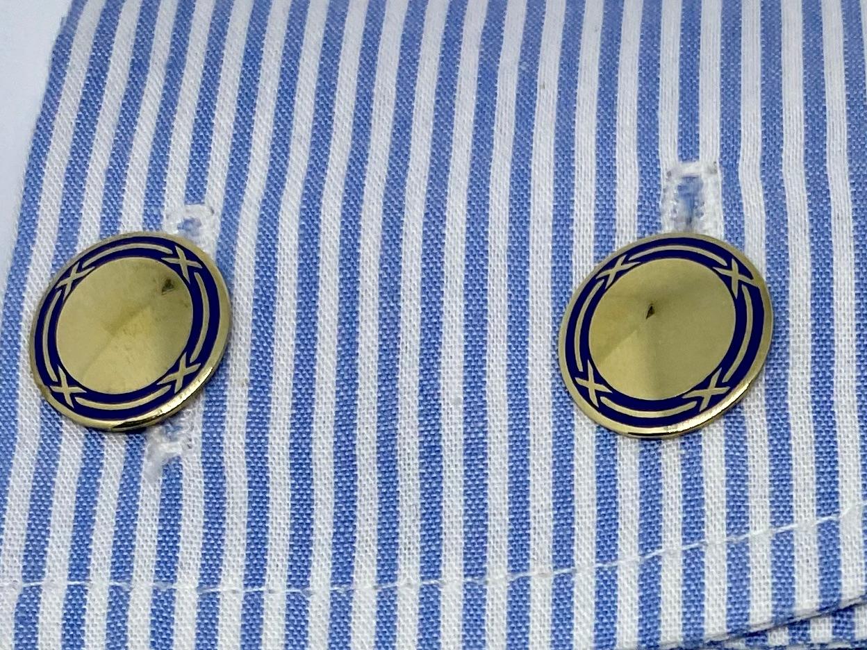 Fantastic, double-sided cufflinks featuring blue enamel details on 14K yellow gold by Sansbury & Nellis, a top American jeweler from the Art Deco era.

Each face measures 14mm in diameter and is joined to its mate by a solid gold connector. Together