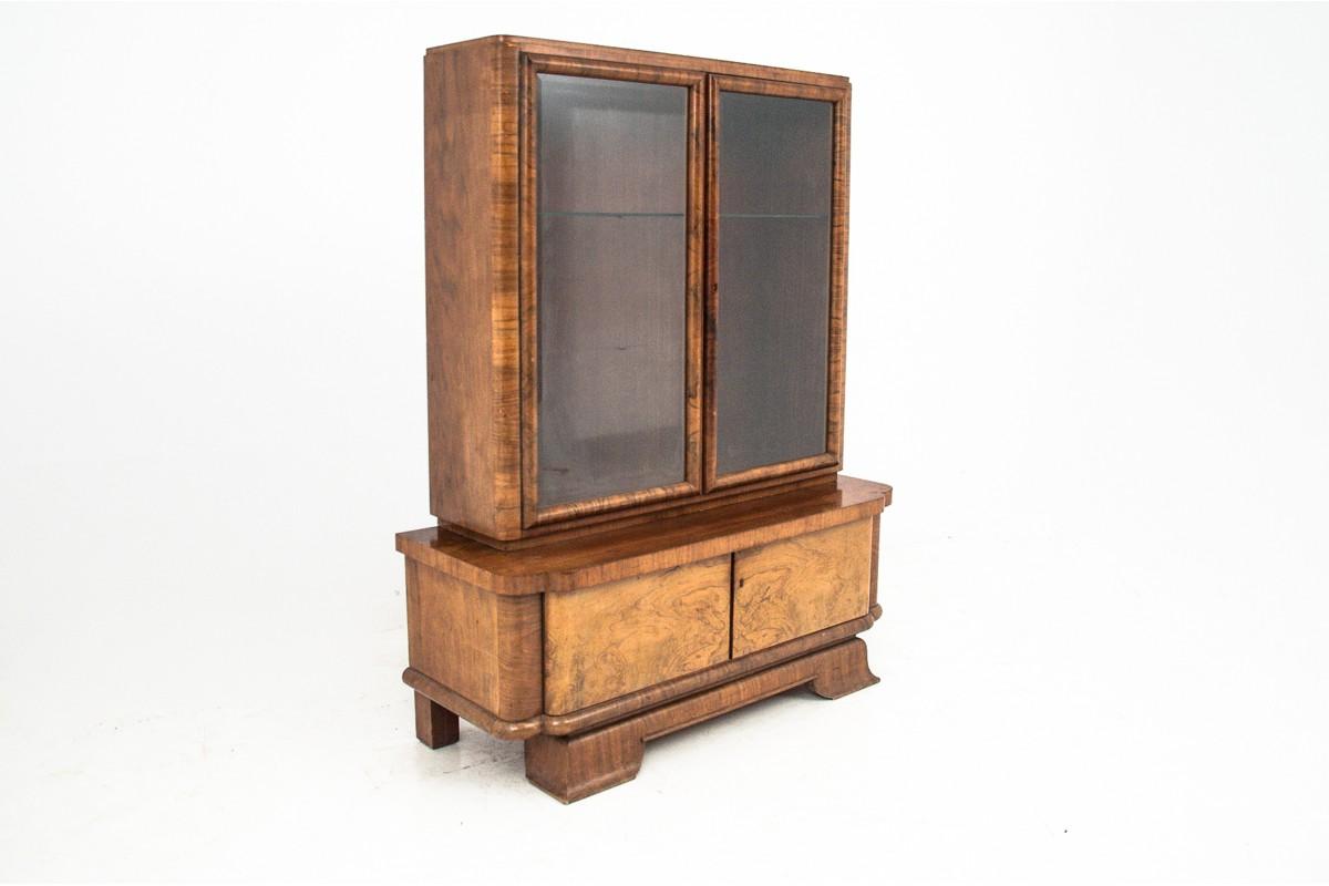 The Art Deco dresser was created circa 1940 from walnut wood. The furniture consists of two parts, the lower part is a two-wing chest of drawers, the upper extension is two door glass display cabinet. Wooden shelves inside, all in the Art Deco