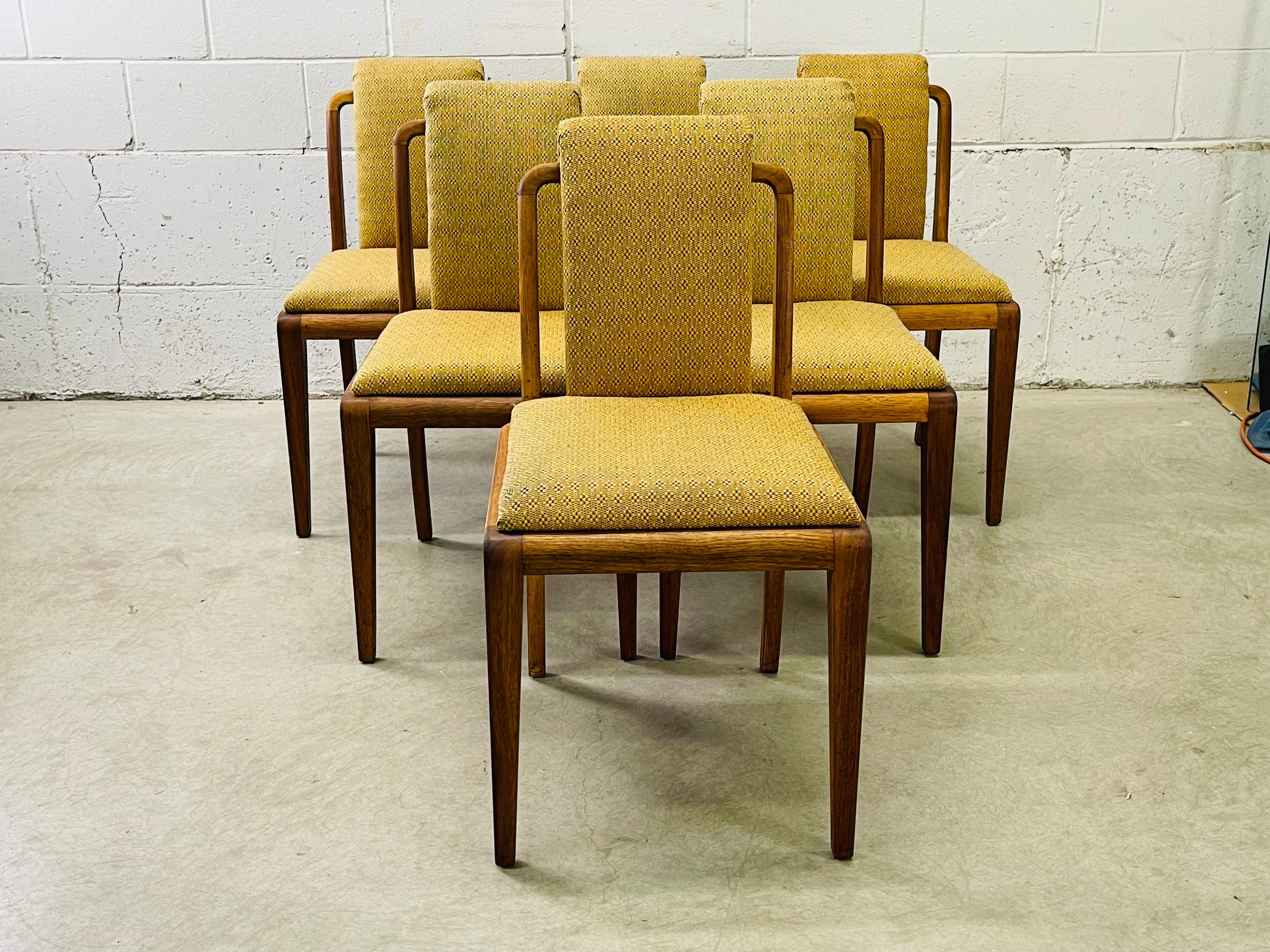 Art Deco set of six curved and open back dining room chairs. The walnut wood frames have been refinished. The fabric is original but in good condition. The chairs are all sturdy. No marks.