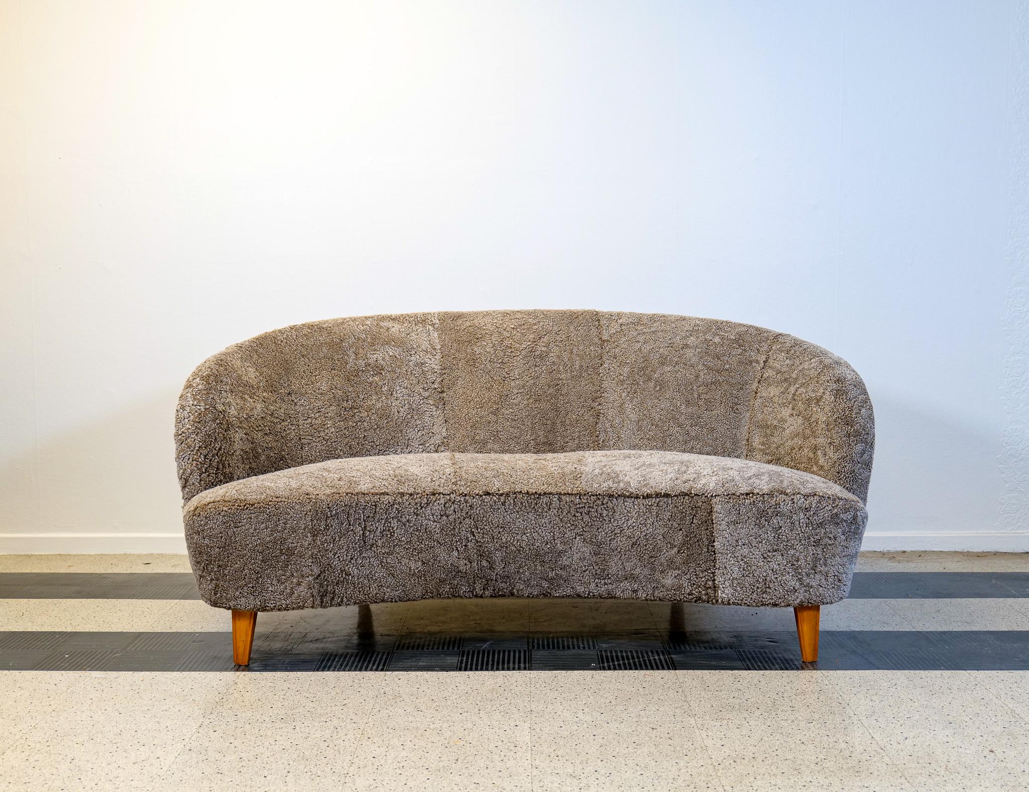 This sofa was made in the 1940s Sweden. The curves and structure on this furniture takes you back to the art deco period. The sofa has been reupholstered in quality sheepskin that gives those curves even more life. 
Nice vintage condition.