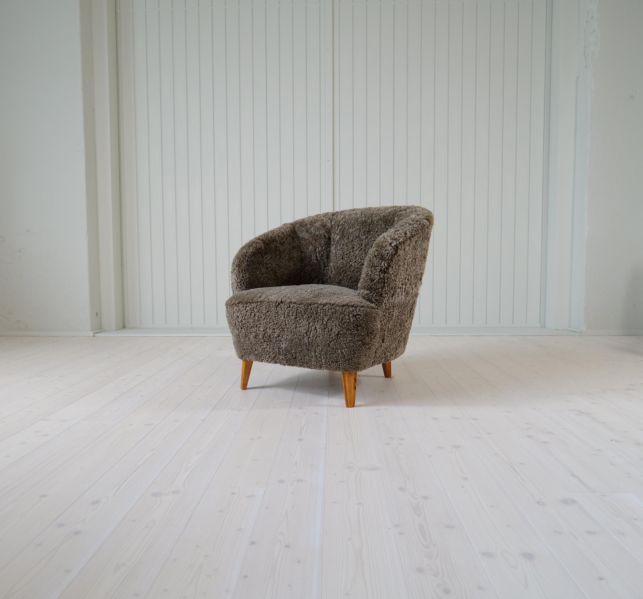 This lounge chair was made in the 1940s Sweden. The curves and structure on this furniture takes you back to the where art deco and midcentury modern are united. The chair has been reupholstered in quality sheepskin that gives those curves even more