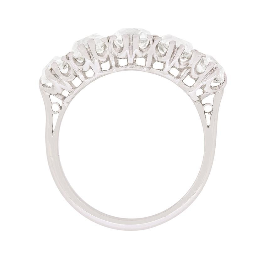 Questo favoloso anello con cinque pietre è composto da vecchi diamanti con taglio a cuscino, che sono stati tagliati a mano nelle loro forme caratteristiche. Al centro dell'anello, il diamante pesa 0,65 carati e le dimensioni aumentano spostandosi