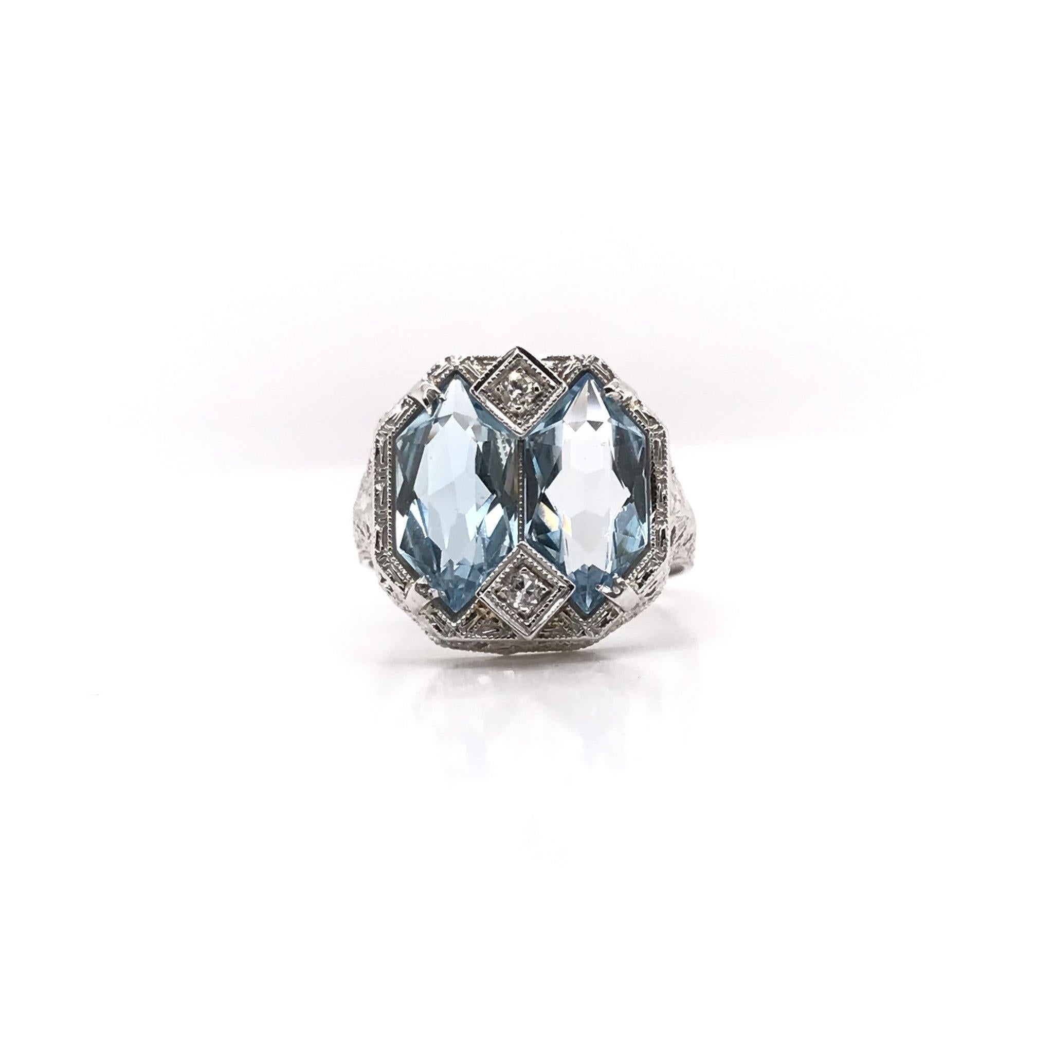 This antique piece was handcrafted sometime during the Art Deco design period ( 1920-1940 ). The filigree setting is 14k white gold and features two custom cut aquamarines. The filigree is arranged in an intricate geometrical motif and features fine