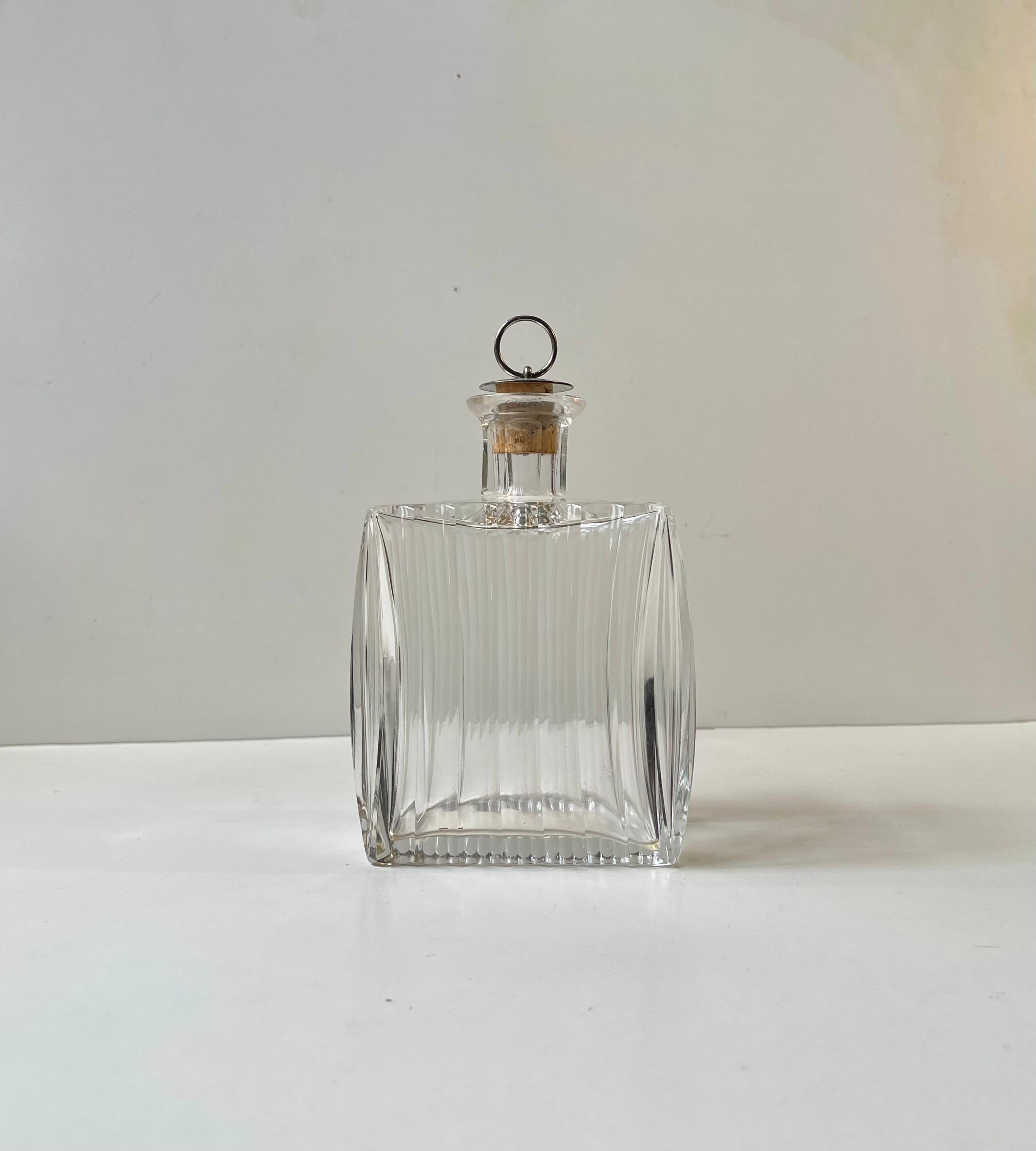 Small scaled square/cushion shaped crystal decanter cut with clean architectural lines and featuring a silver-plated cork-stopper. Probably made by either Holmegaard or Lyngby in Denmark during the 1930s. Reminiscent in style to similar pieces from