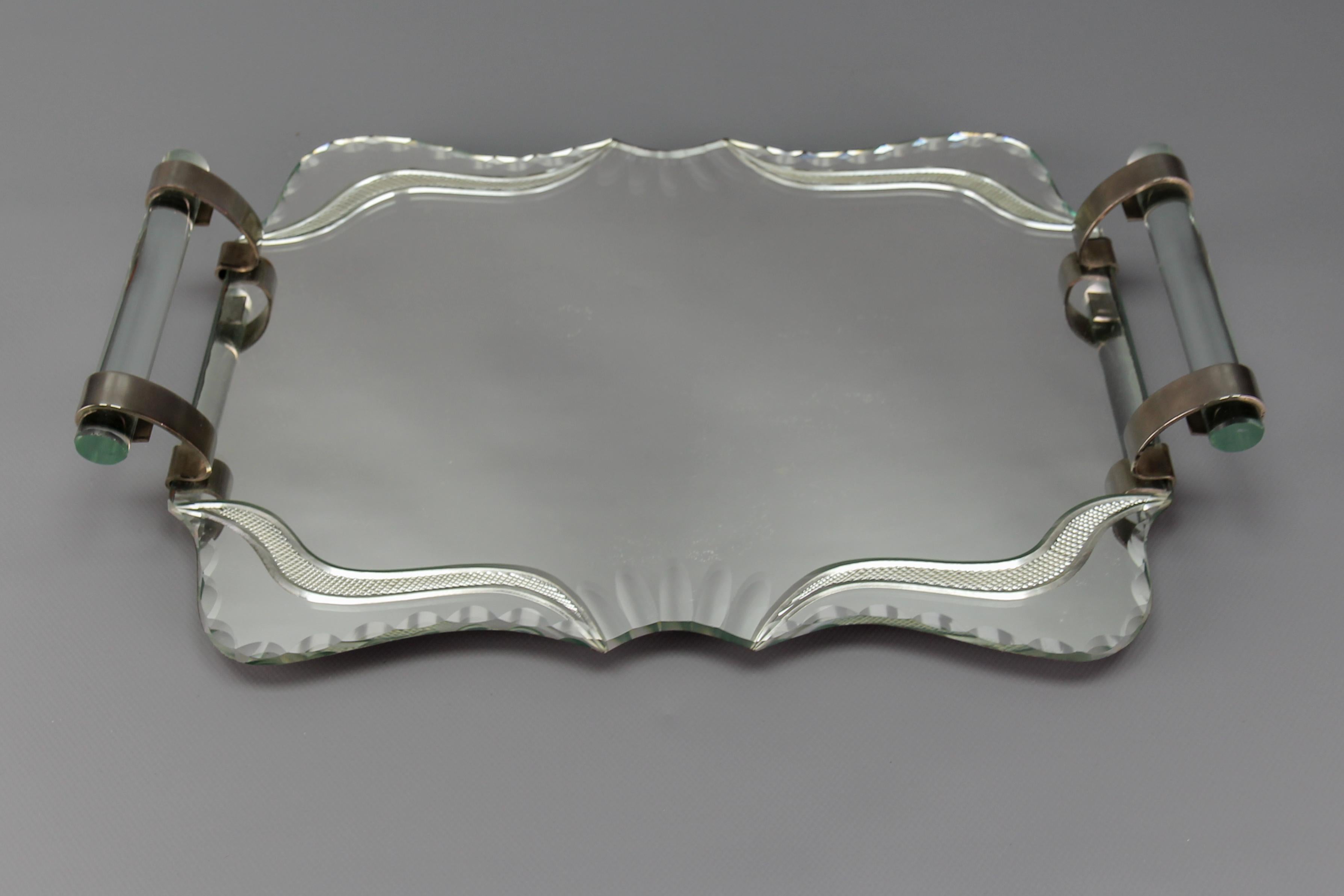 Art Deco cut Mirror, glass, and chrome serving tray, France, 1930s.
An elegant and classic Art Deco serving or bar tray made of a cut mirrored base with beveled details. Handles are made of thick glass and chromed aluminum.
Dimensions: height: 7 cm