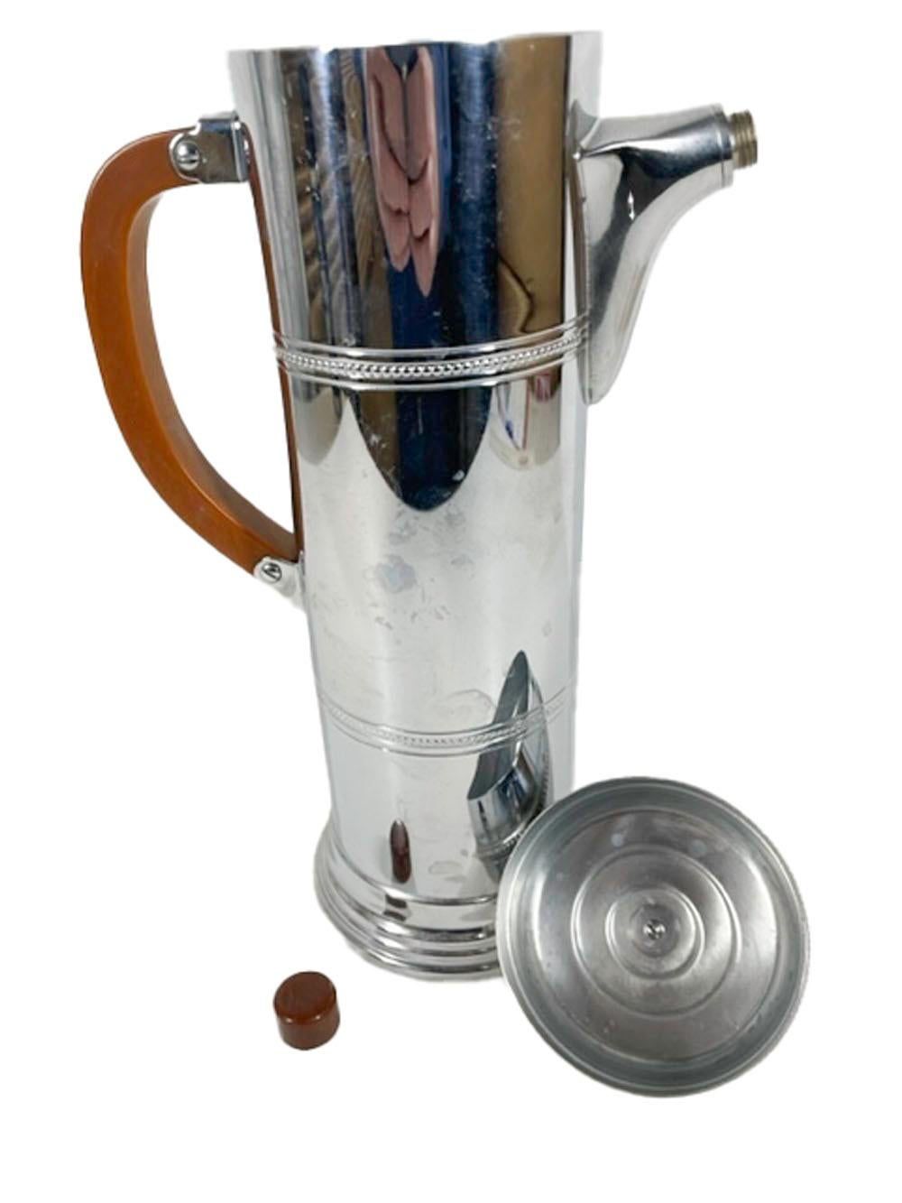 Art Deco chrome cocktail shaker of cylindrical form with beaded bands attributed to the Krome-Kraft division of Farber Brothers. Having a chocolate Bakelite handle as well as lid and spout knobs.