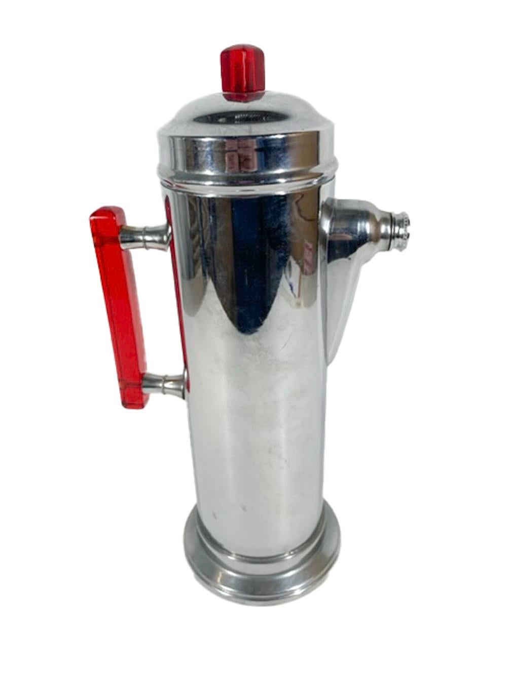 Art Deco chrome cocktail shaker of cylindrical form with a square translucent red Lucite bar handle on turned standoffs and a stepped lid with a square Lucite knob with a pyramidal top. Mark ed on the bottom in circular text 