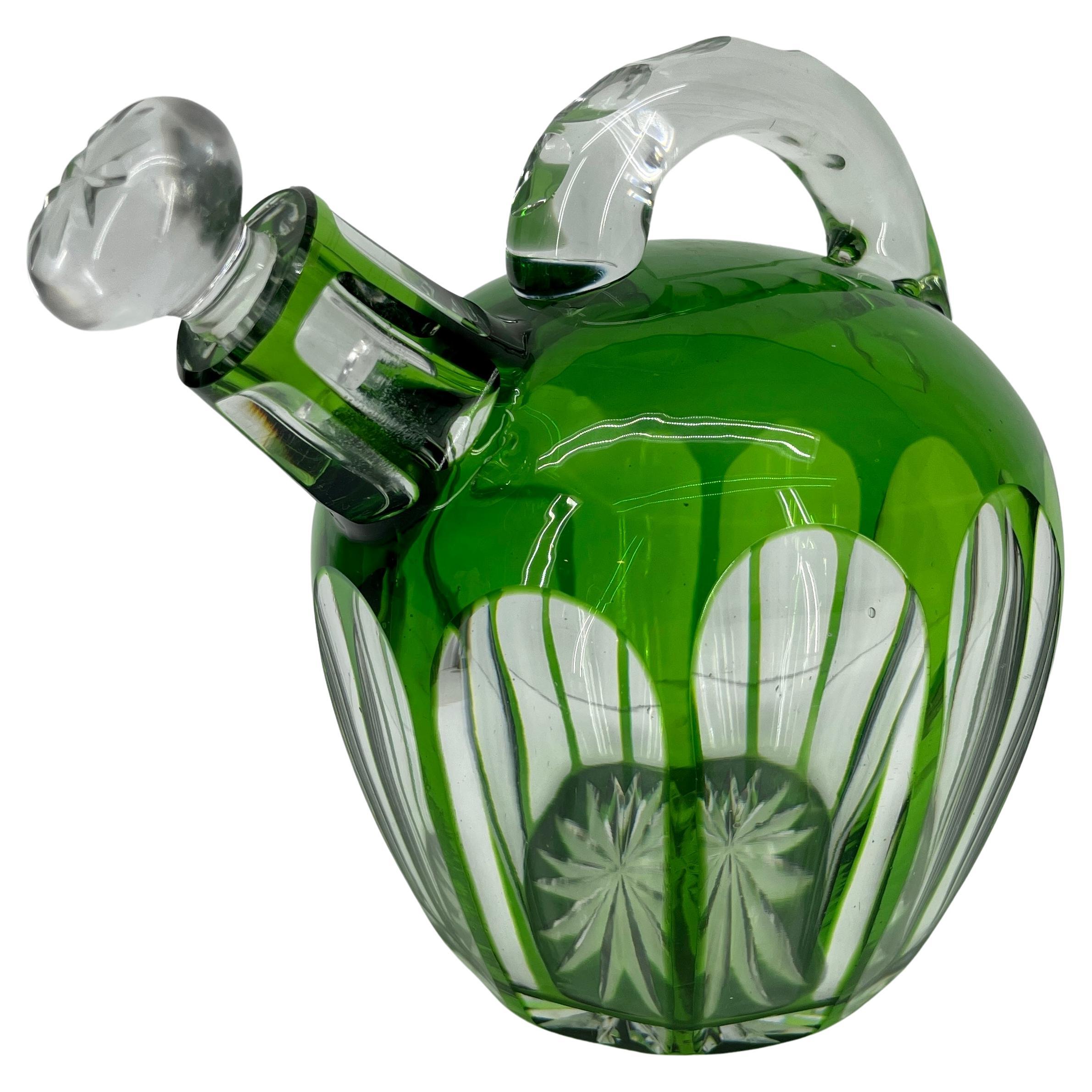 Art Deco Bohemian cut glass decanter with stopper. This beautiful glass decanter is high quality; striking green to clear glass. The glass is overlaid with gorgeous green throughout the body as well as the starburst pattern on bottom and beveled