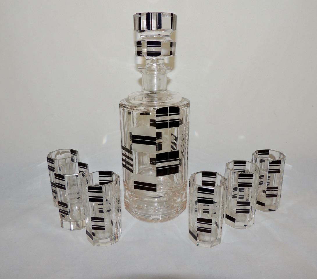 An Art Deco decanter and glasses – a Czech set with a “Checked” design. This is a substantial piece in crystal with faceted sides, and a combination of ebony black and clear frosting and etching. A hefty stopper refracts the light like a prism