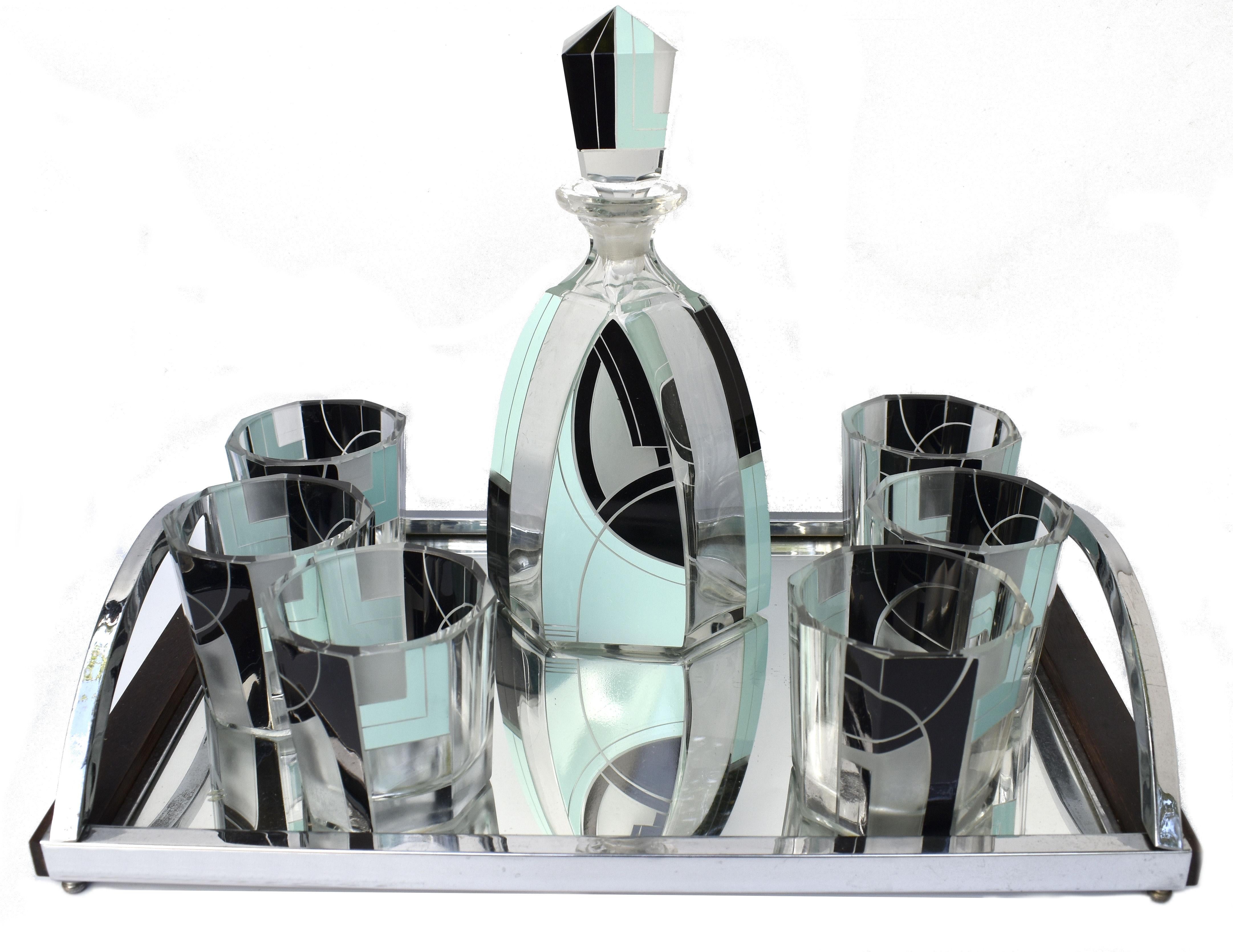 Extremely stylish Art Deco decanter set dating to the 1930's and originating from Prague, Czech Republic. Geometric enamelling in a pale teal and jet black decorate the attractive the stunning shape glasses. Comprises decanter with stopper and 6