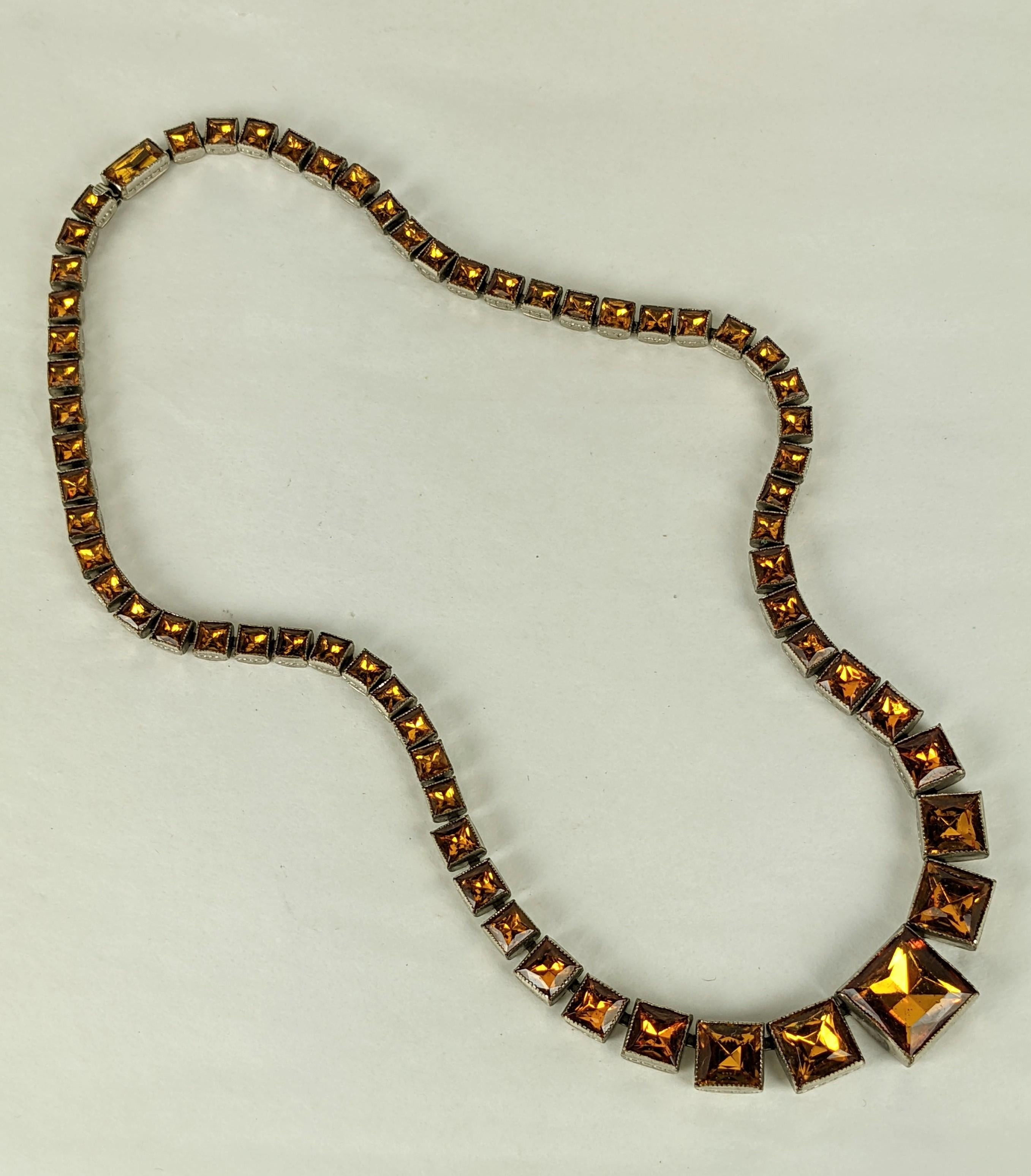 Élégant collier Art déco en pâte à modeler tchécolovaque des années 1930. Les montures carrées flexibles sont graduées jusqu'à la plus grande pâte de topaze au centre. Plaqué argent. Fleurs gravées sur le dos. Signé 