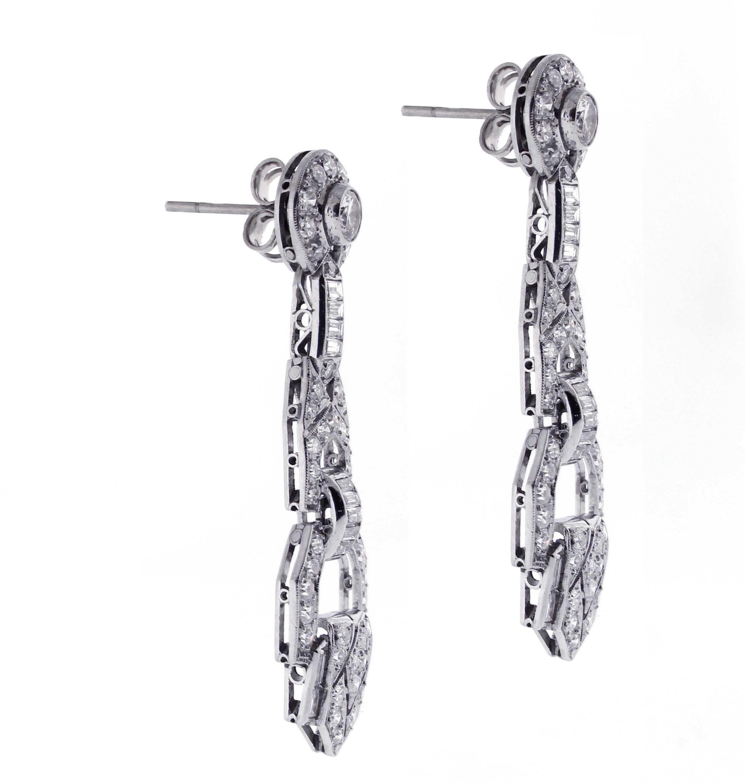 From the 1920s a glamorous pair of Art Deco diamond drop earrings
♦ Metal: Platinum
♦ 92 Round diamonds=.90 carats
♦ 2 Round diamonds=.50 carats
♦ 26 baguette diamonds=1.35 carats
♦ 1 ¾ inches High
♦ circa 1920s
♦ Packaging: Pampillonia presentation