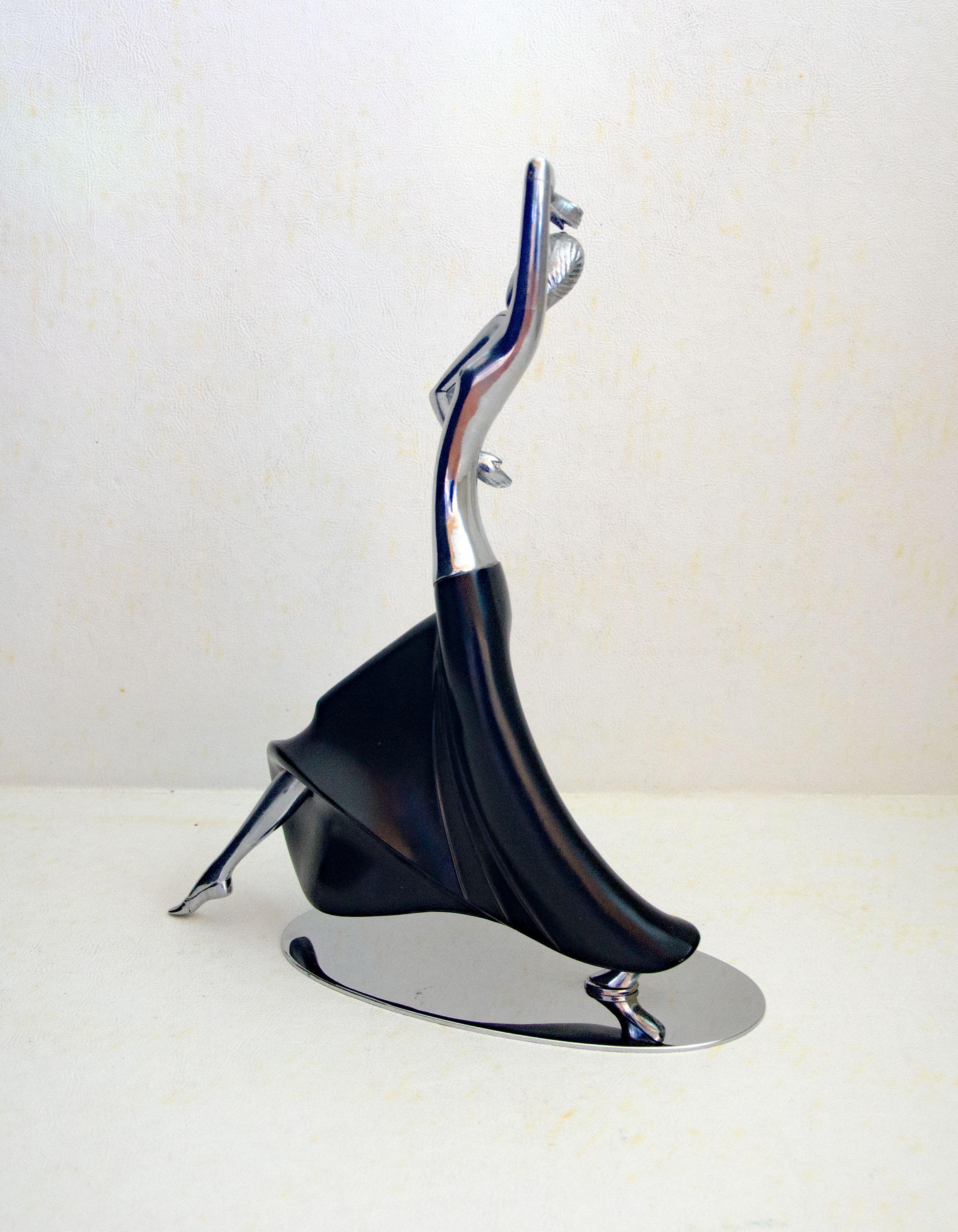 Beautiful non-ferrous sculpture of a semi-nude dancing female. The figurine is as heavy as brass or bronze, only the oval chrome-plated base is magnetic. The sculpture has a very sensuous appearance with a nude upper body and a flowing painted metal