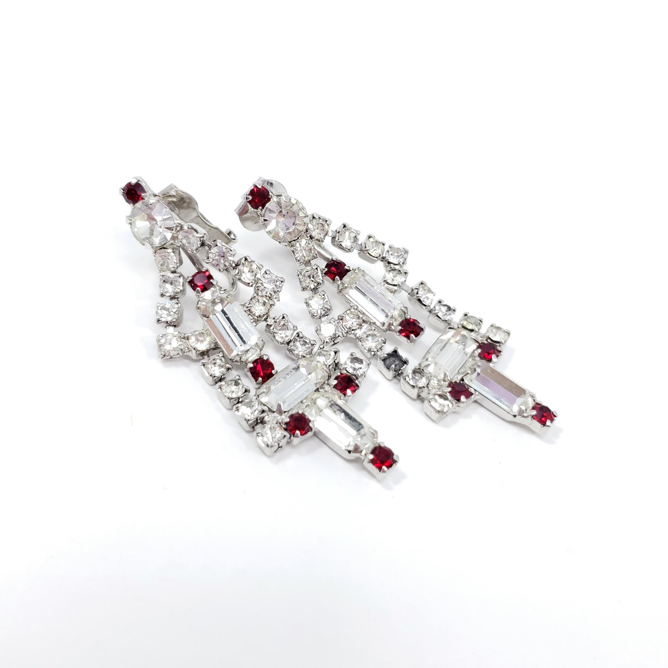 Stylish, glittering art-deco clip on earrings. Round and baguette-cut crystals, prong-set in a dangling deco setting.

Silver-tone.