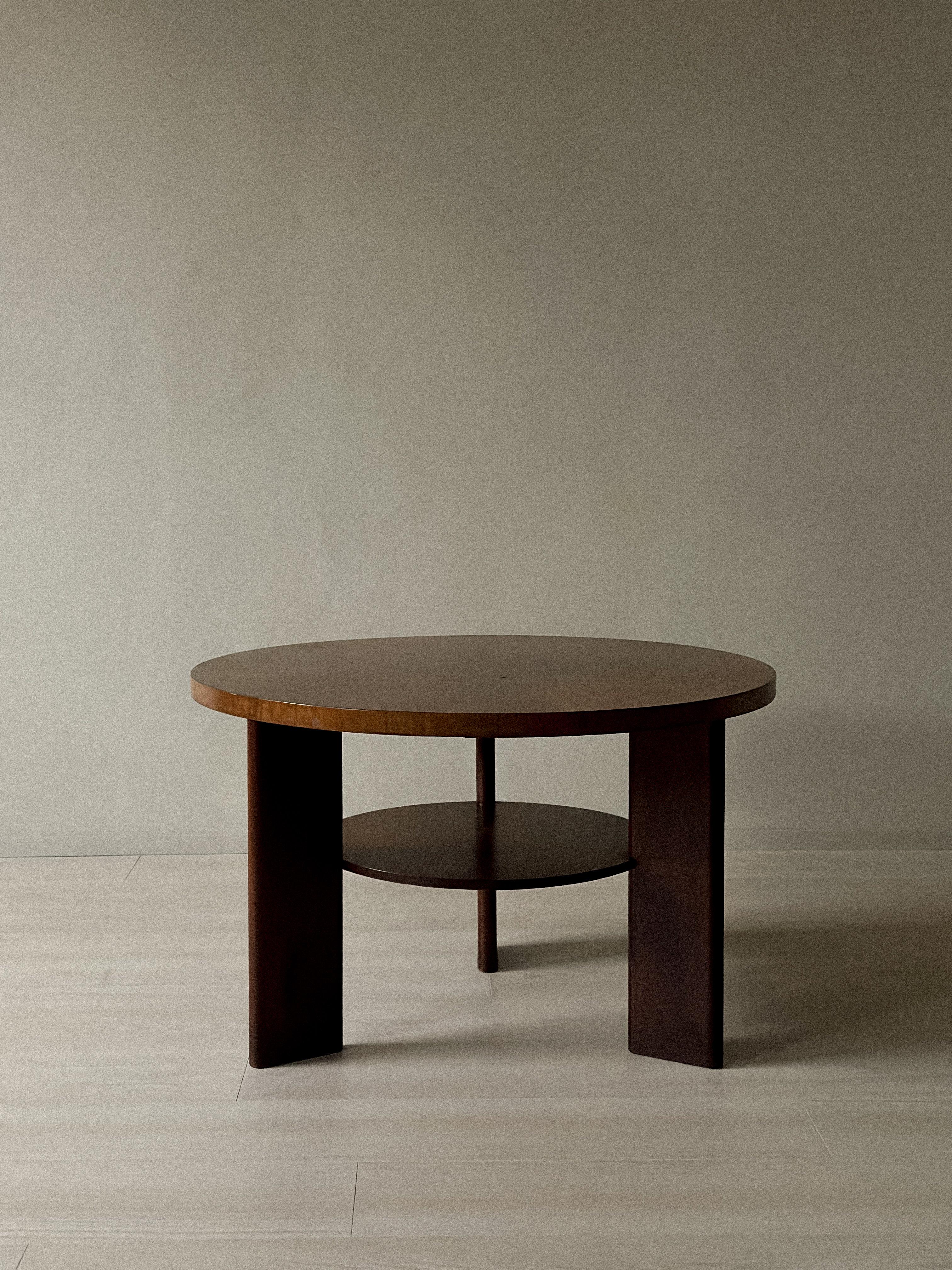 Circular coffee table on three legs with underlying shelf presumably made by a Danish master carpenter in the 1930/40s.

Table top, shelf and legs veneered with lacquered mahogany. Unmarked.
