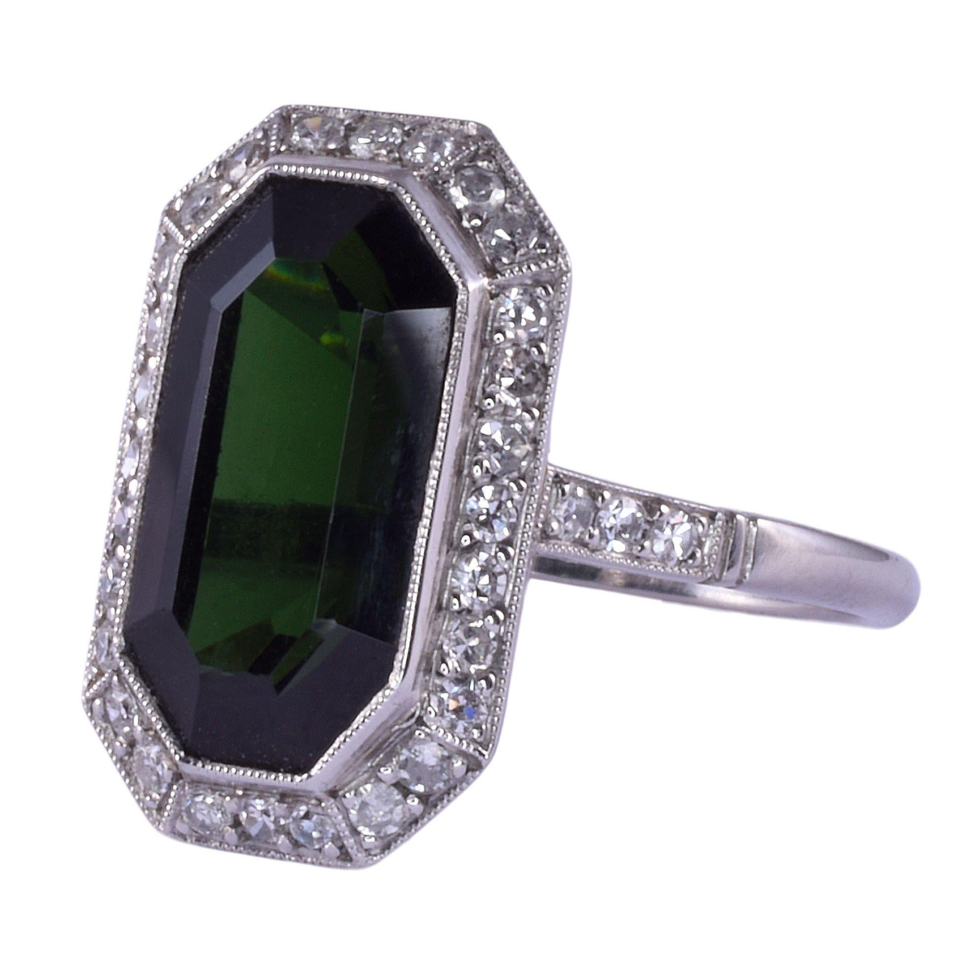 Vintage Art Deco dark green tourmaline platinum ring, circa 1930. This Art Deco ring is crafted in platinum and features a 4.06 carat dark green tourmaline encircled with .50 carat total weight of single cut diamonds. The diamonds have VS1-SI1