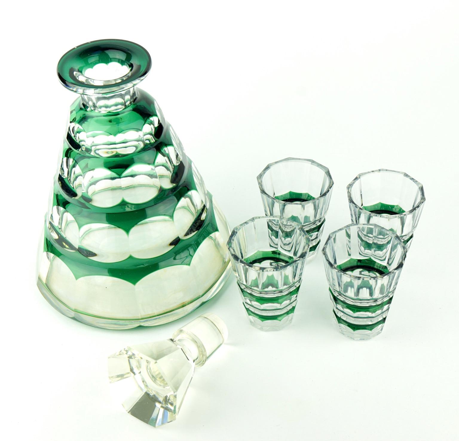 A crystal decanter set with four glasses in very good condition. Original stopper. The decanter has a tapered eight sided panel cut stopper and ten sided facet cut sloped body, the glasses have ten sided bucket forms.

Size:
Decanter, height 22.5