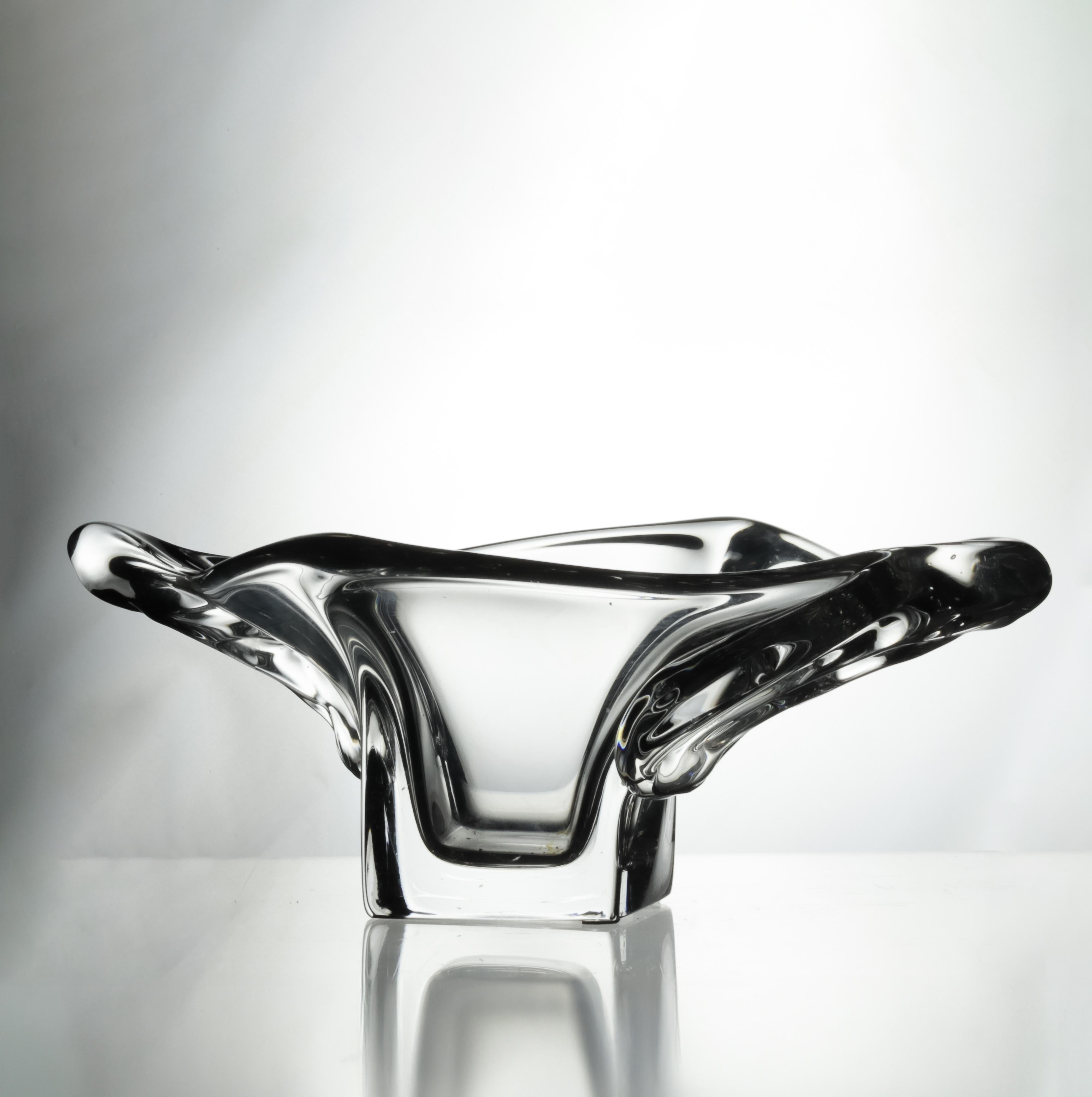 This Art Deco crystal centerpiece was masterfully created by Daum, one of France’s most celebrated glassmakers, circa 1950s. 
Molded in clear, high-quality crystal, the piece features thick, flowing layers of glass that create a sense of movement
