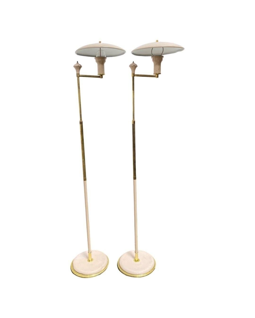 Pair of Gerald Thurston designed, Mid-century Modern saucer-style floor lamps comprised of brass with a neutral nude-colored enamel. The lamps feature a height-adjustable neck and a double bounce shade for soft easy read light.
 
Standard medium