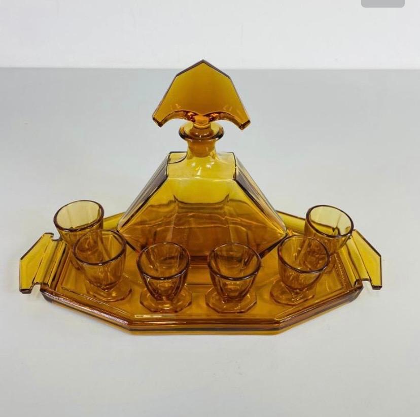Art Deco honey glass set consisting of a carafe, 6 shot glasses and a tray. Very good condition. Produced in Czech in the 1930/40.
Height of the carafe : 20cm width 16 cm depth 8 cm.
 