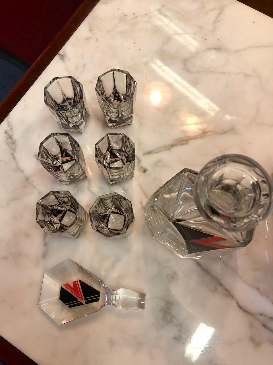 An original 1930s Art Deco decanter set with six glasses by Karl Palda, set in chrome and black glass tray. The design is a striking “lightning bolt” of red and black in high-quality Czechoslovakian crystal. This favorite glass master produced
