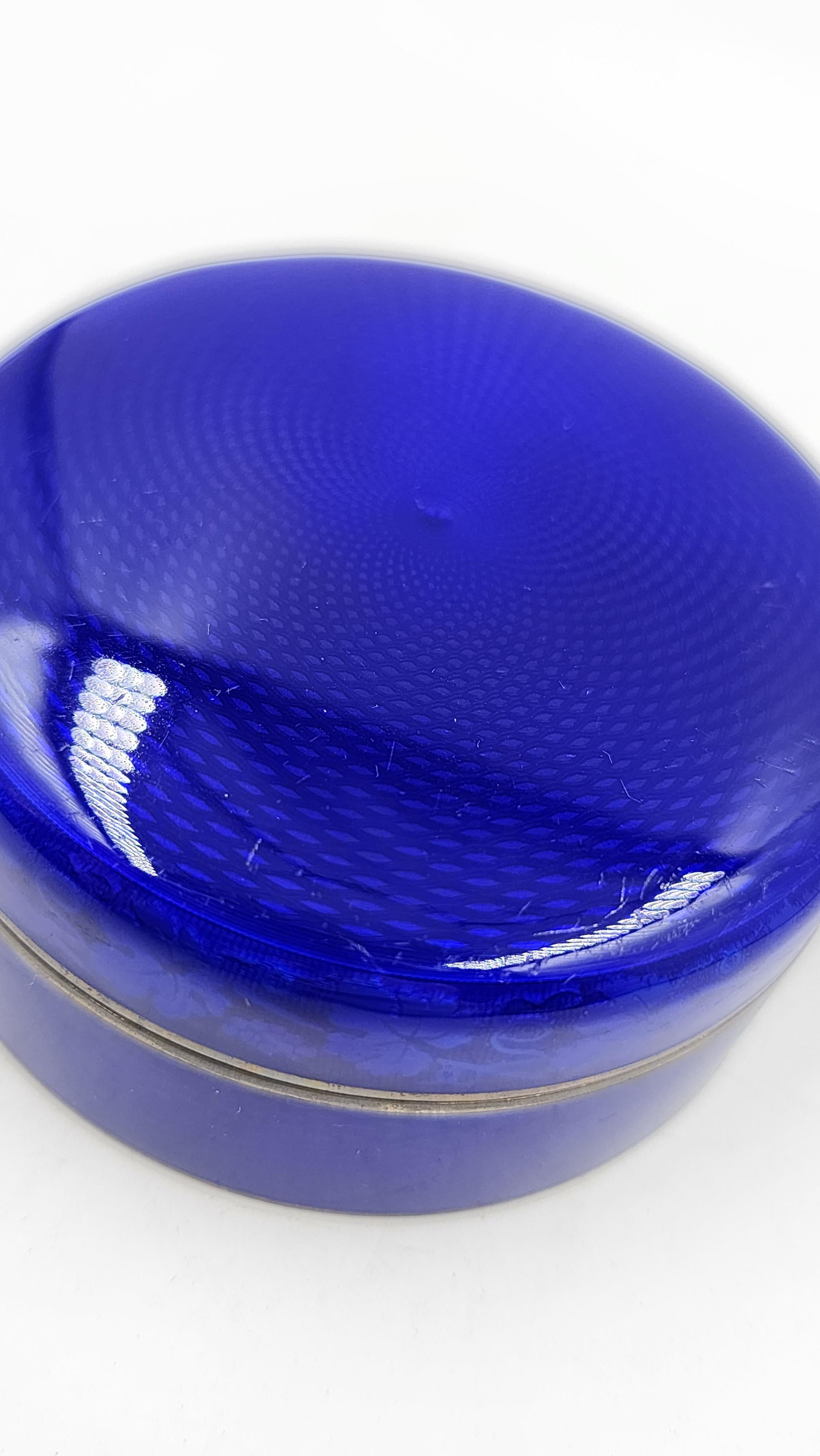Boîte décorative Art Déco en argent sterling avec émail bleu
Cette boîte décorative Art déco présente une forme circulaire et un design sobre. L'extérieur est recouvert d'un émail bleu cobalt vibrant sur une base en argent sterling avec une délicate