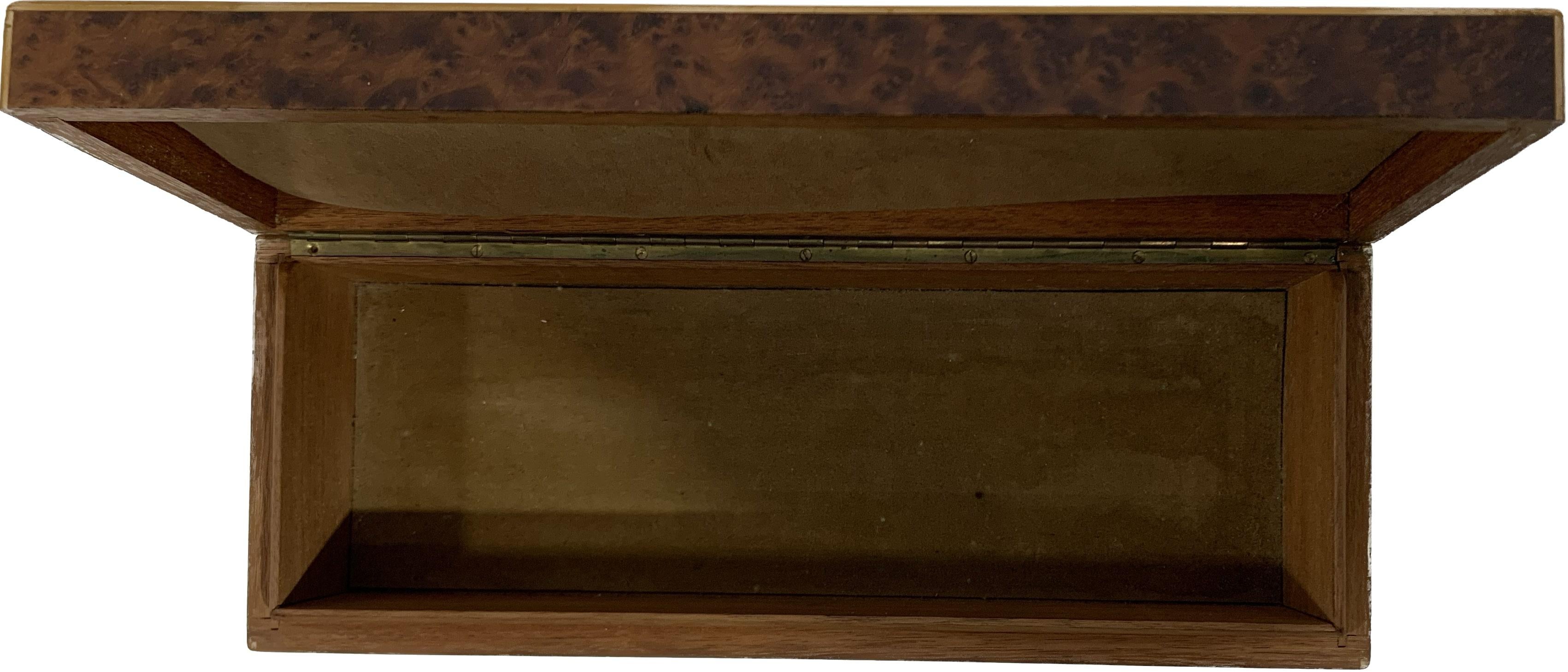 Boîte en bois du milieu du 20e siècle, directement issue de la période Art Déco et fabriquée à l'origine en Europe, en France. La technique utilisée est celle de la marqueterie avec des incrustations polychromes de différents bois comme le bois de