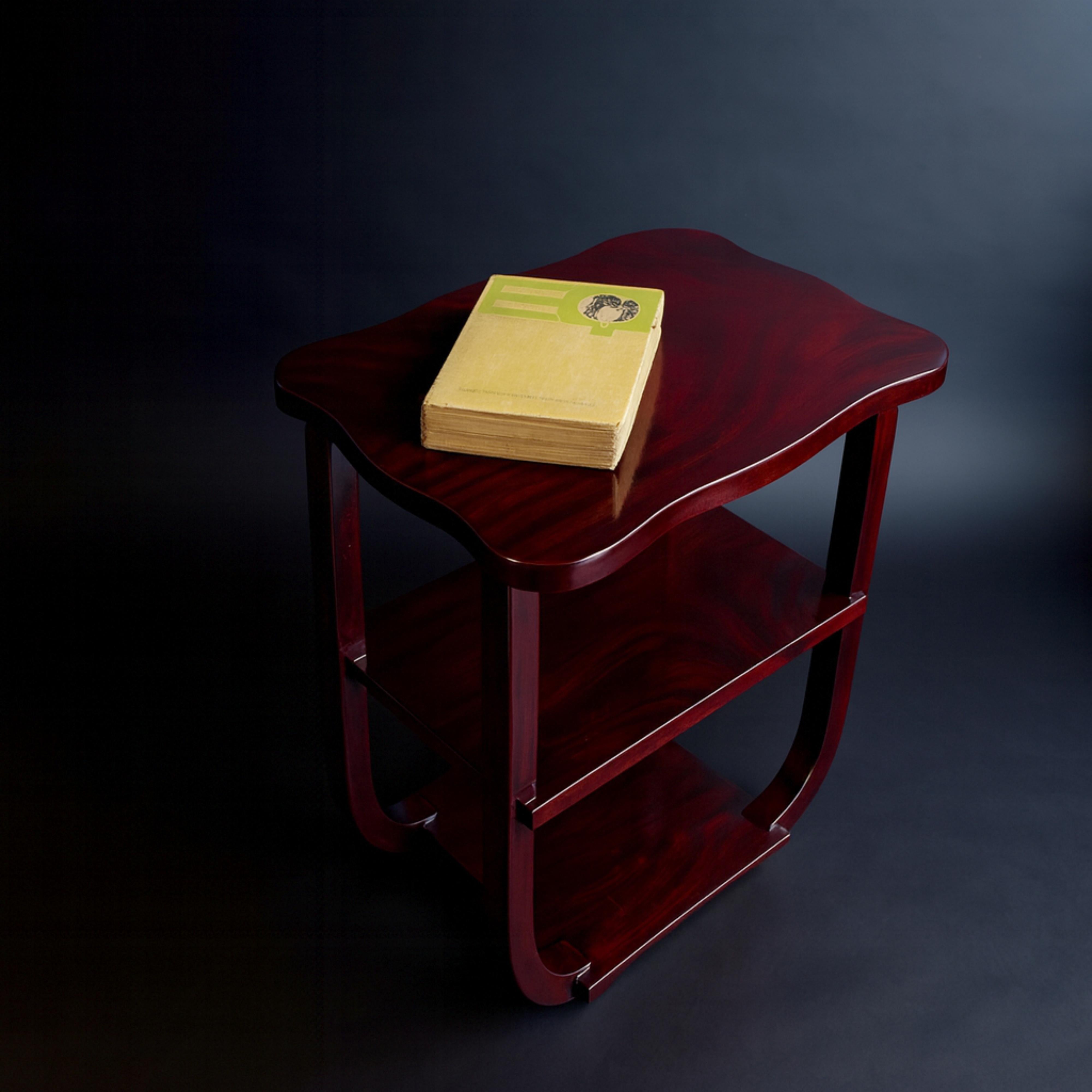 Un tavolino Art Déco del XX secolo, rifinito in borgogna profondo. Design geometrico con un cassetto singolo per riporre gli oggetti e un'elegante base curva.

Tieni presente che i colori degli articoli possono variare a seconda del tipo di
