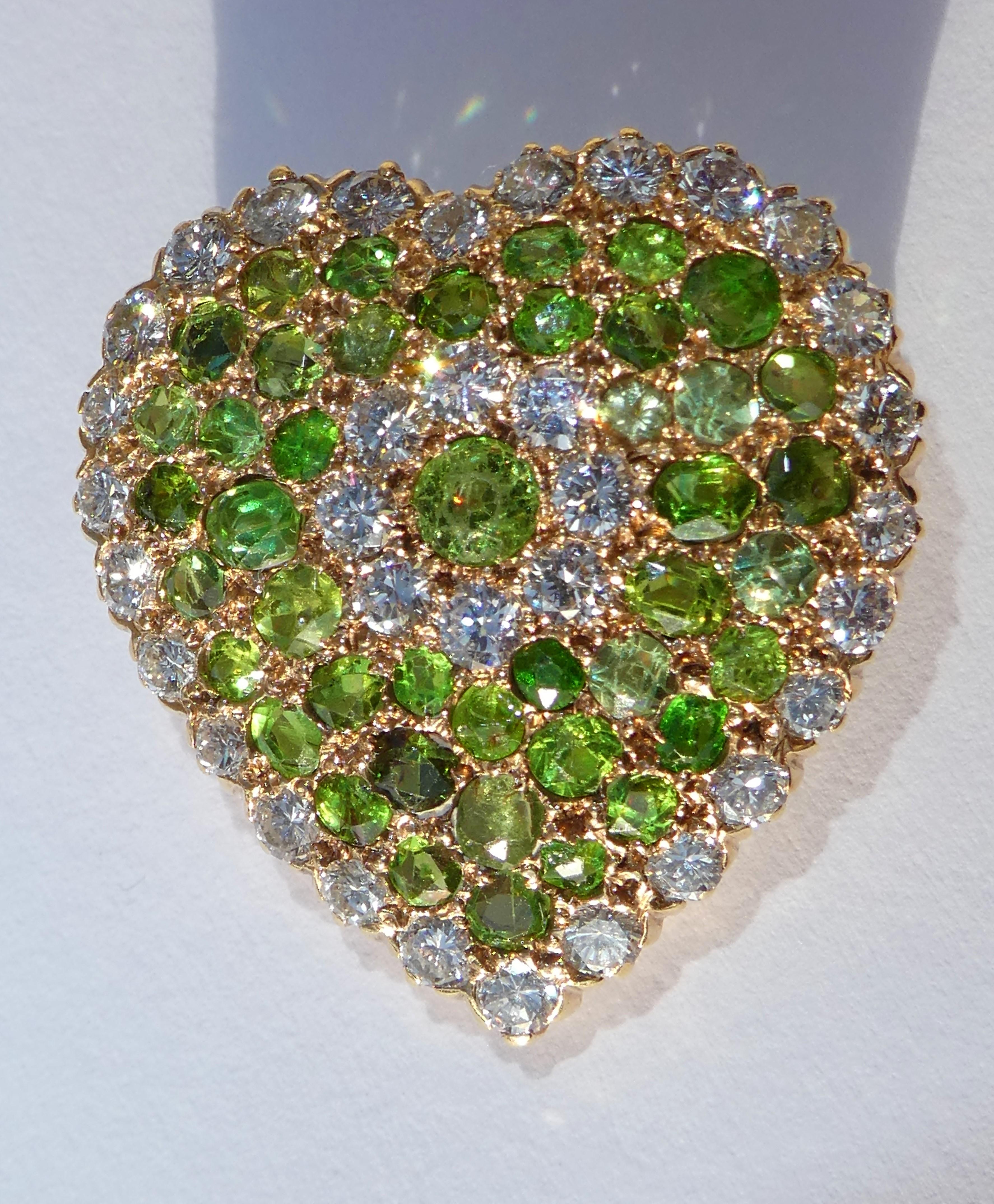 This green heart was crafted circa 1915 in the United States in 14 karat gold. It is so special because it is pavé set with 46 rare green demantoid garnets in different sizes of ca. 4,2 carat and 34 round Brilliant cut diamands of high colour and