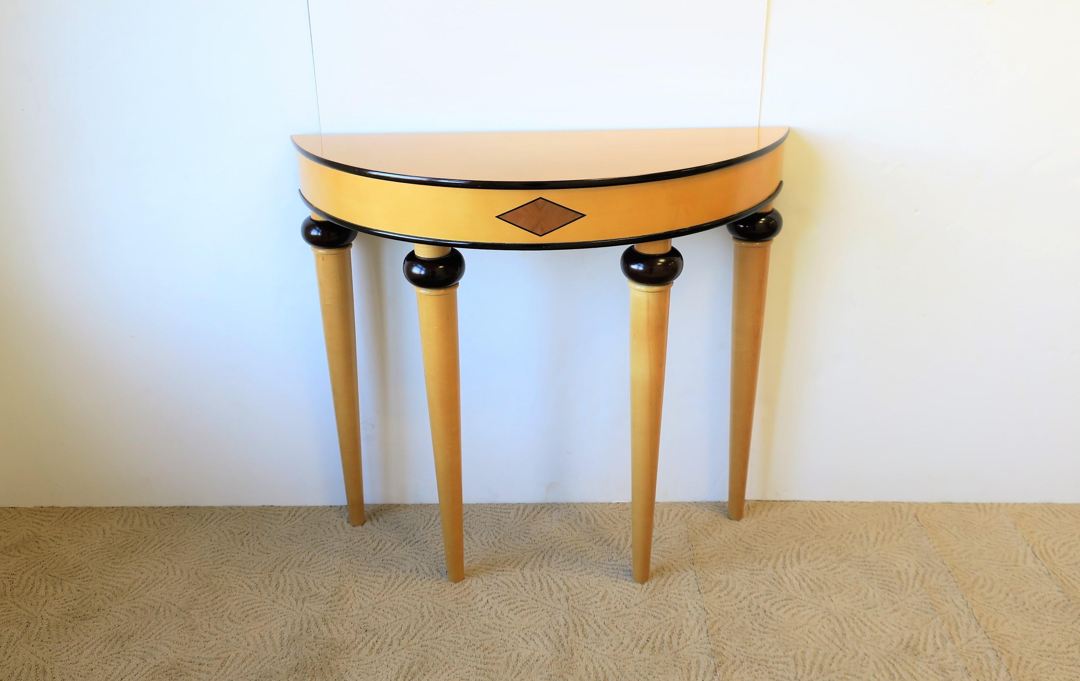 A striking late 20th century Art Deco style Demilune or 'halfmoon' wood console table, 1995. Console is blonde and ebony colored wood. Console may be convenient for a foyer or hall area. Measurements include: 30