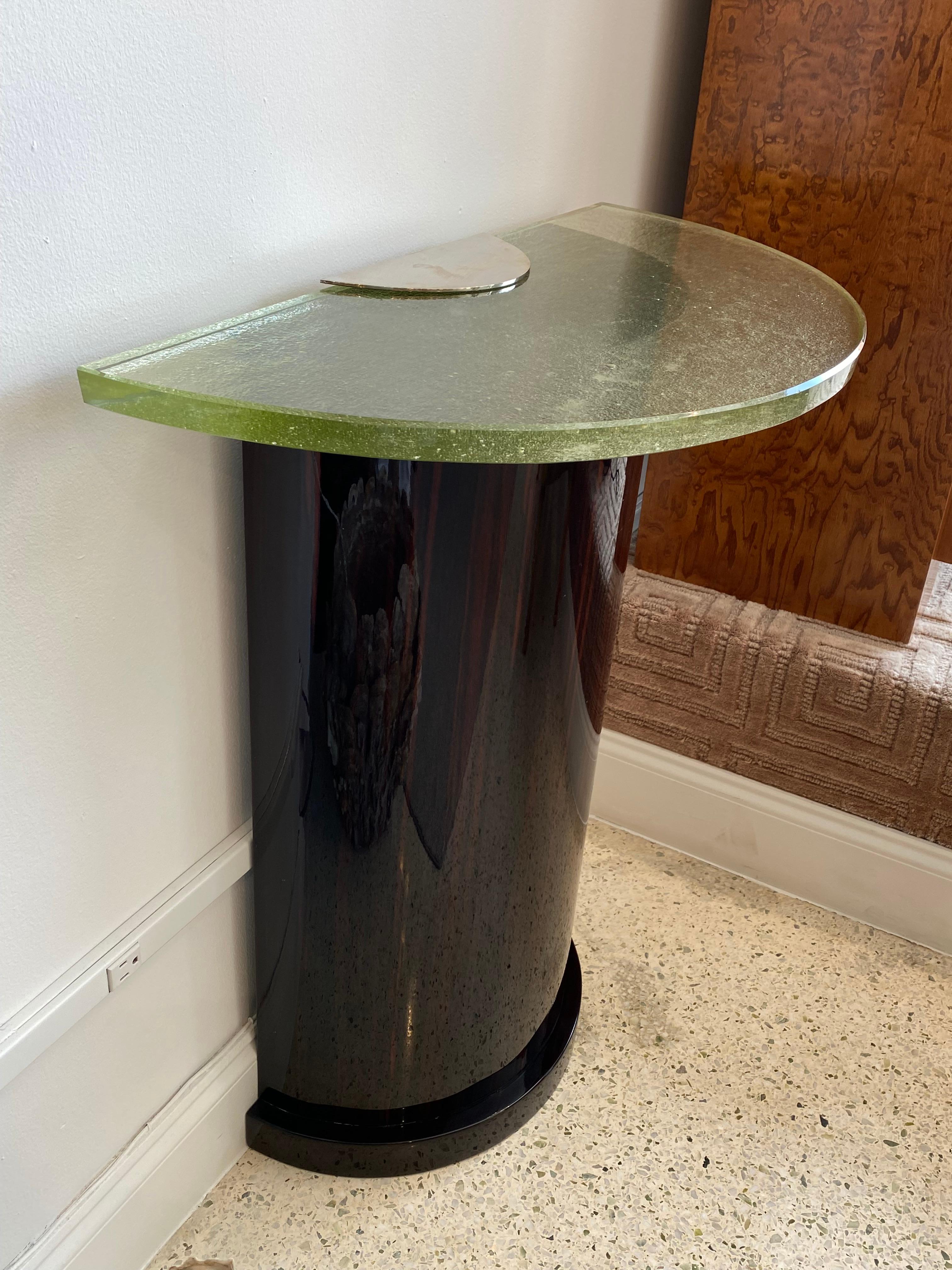 Art Deco demi-lune console table, made out of makassar ebony veneered mahogany with decorations in nickel-plated metal and semicircular pebbled glass top.
Made in France,
circa 1990.