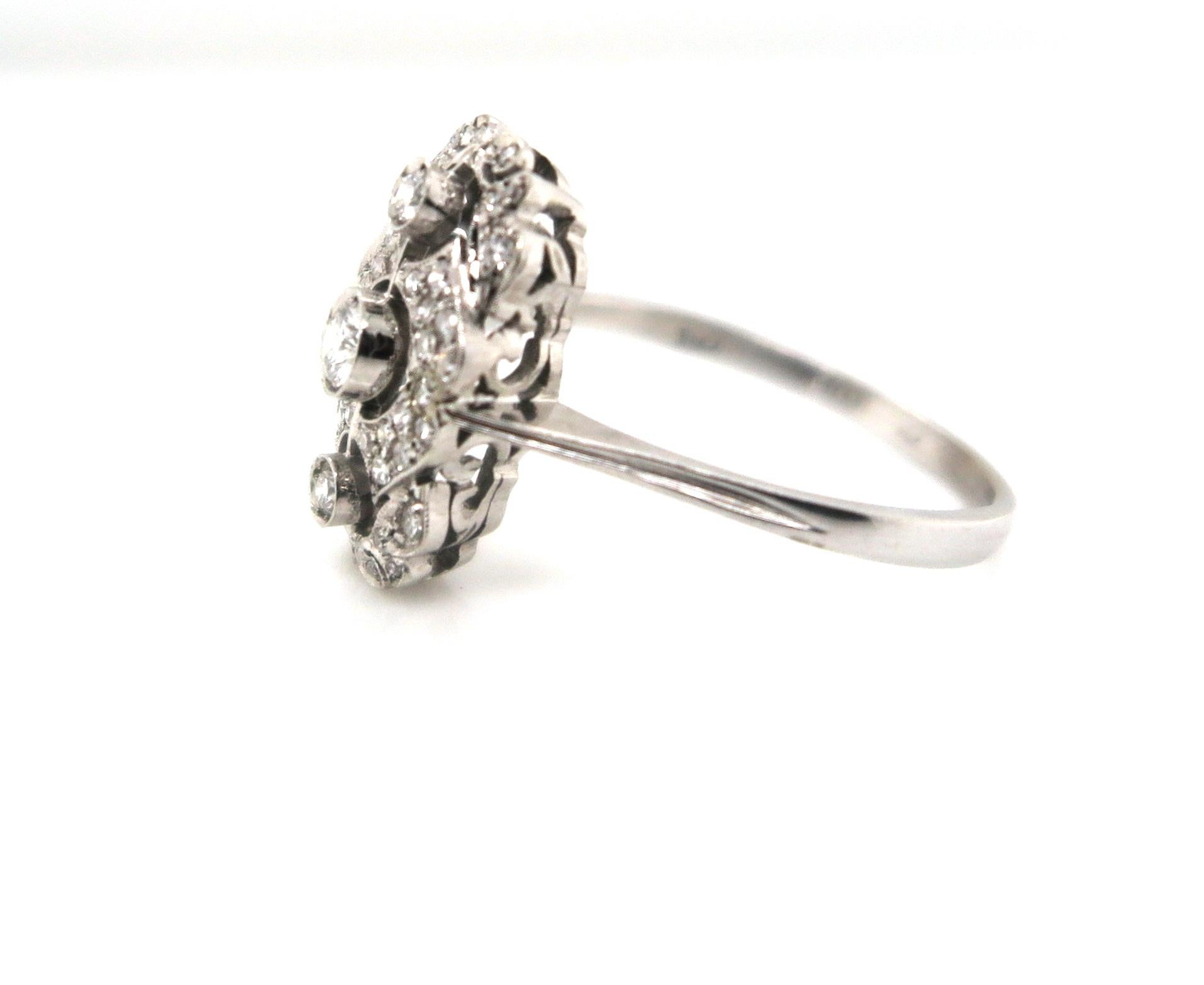 Dainty and one-of-a-kind, this is an Art Deco inspired ring is crafted in 18K white gold. This ring also features three Round Brilliant cut diamonds in the centre and intricately placed fine round brilliant diamonds around the central diamonds. With