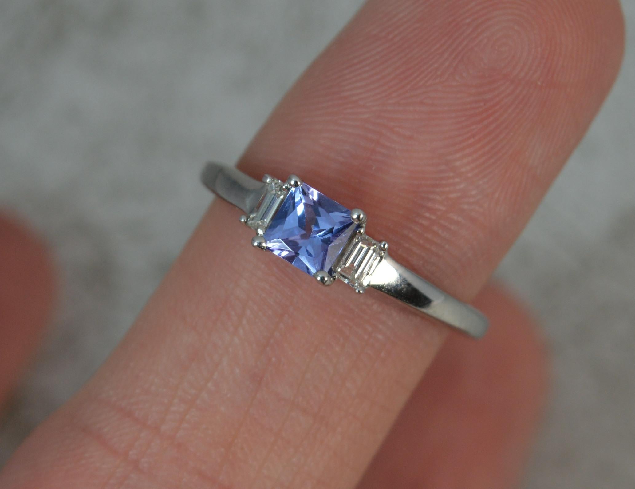 A superb ladies Tanzanite ring.

Solid 18 carat white gold shank and setting.

​Designed with a natural princess cut tanzanite to the centre and baguette cut diamond to each side.

4.3mm diameter tanzanite.

CONDITION ; Excellent. Well set stones.