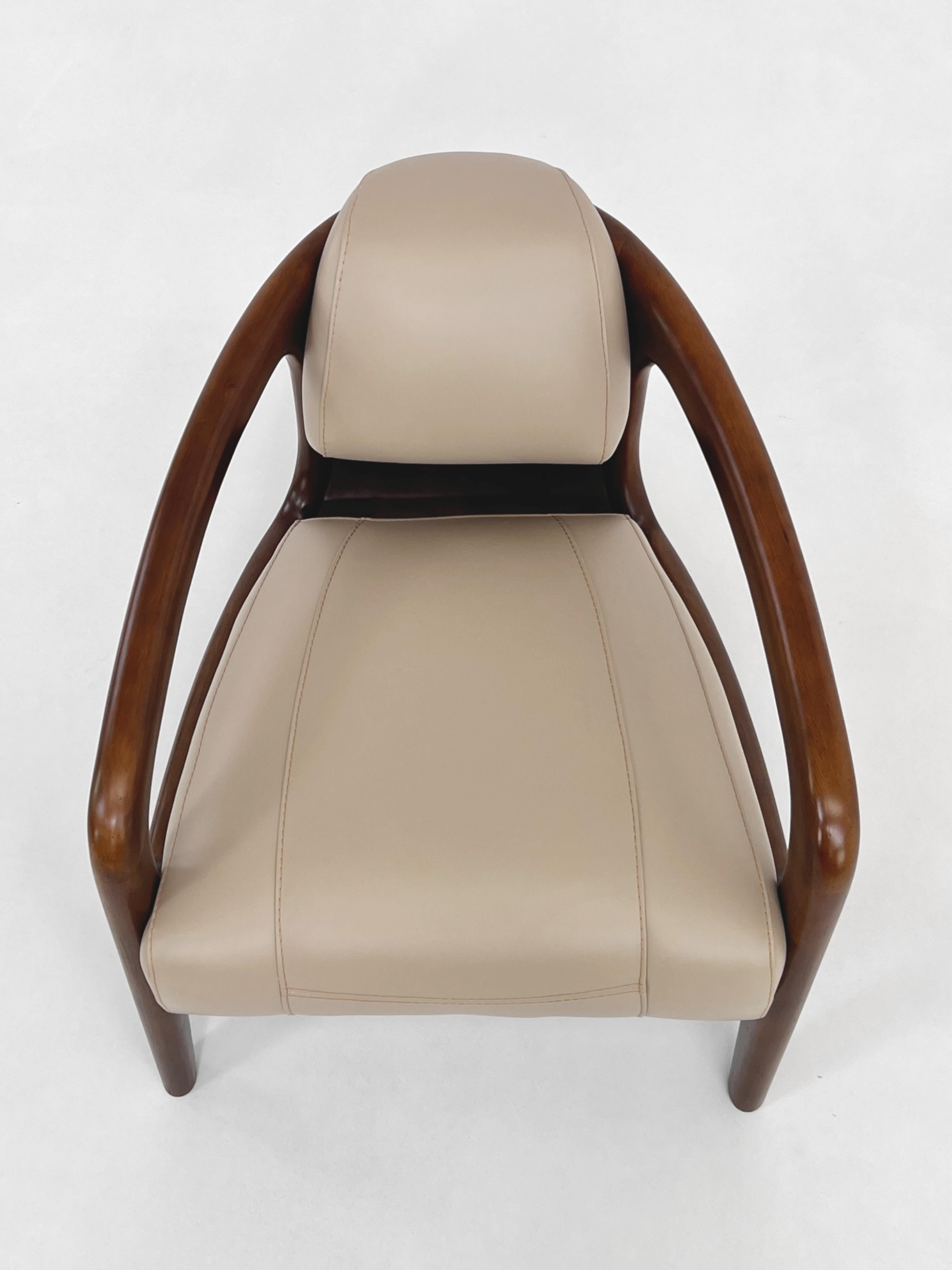 Art Deco Design Style Wooden And Leather Armchair composed of a wooden and curved structure with a comfy seat made in cream leather.