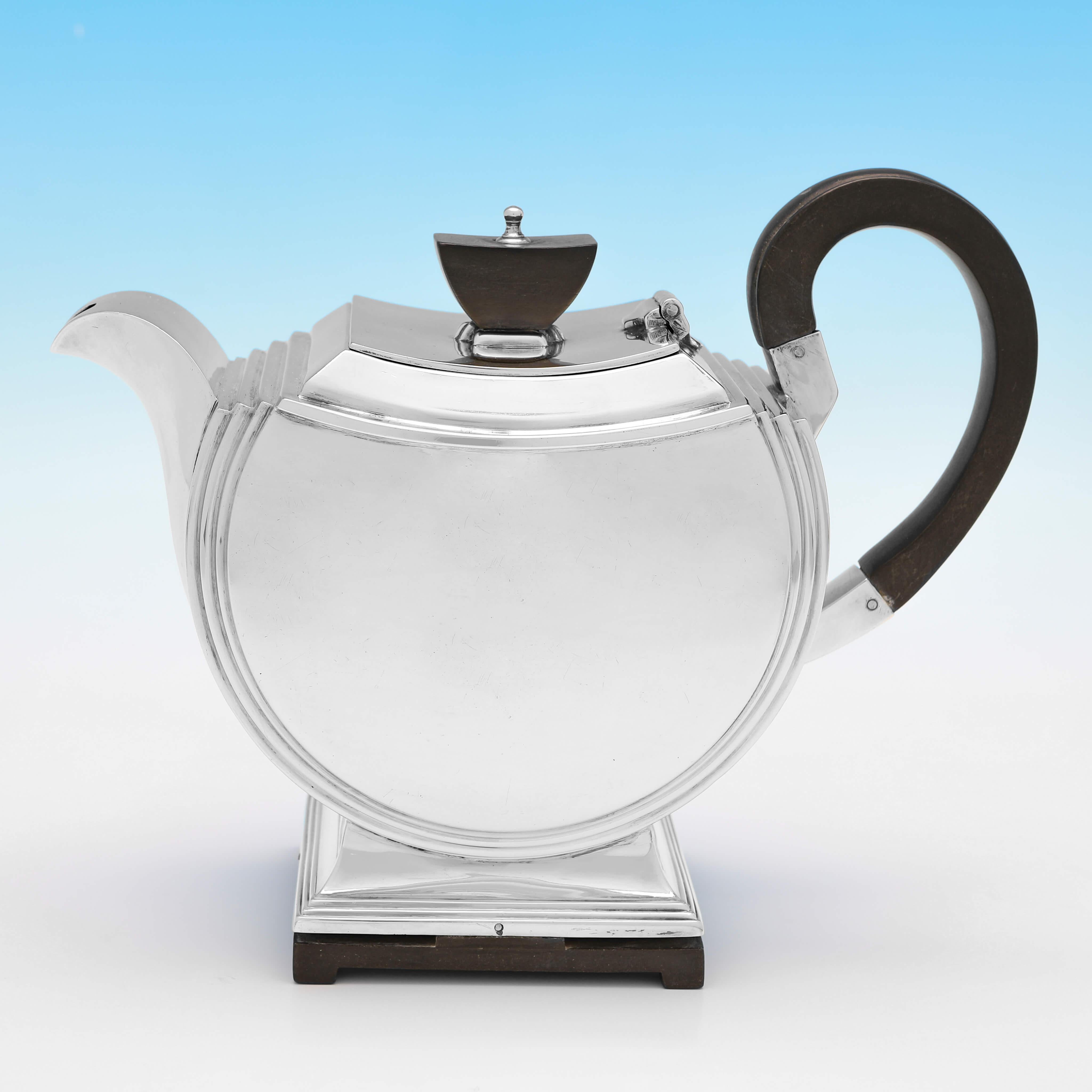 Hallmarked in London in 1947 by Walker & Hall, this fantastic, Sterling Silver Tea Set, is the height of Art Deco design, with a wooden base, handle and finial to the teapot. 

The teapot measures 5