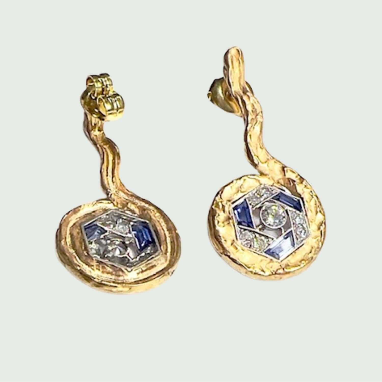 These stunning earrings boast an Art Deco design, crafted in 18k gold with platinum 950 kts accents. They feature antique and single-cut diamonds totaling 1 carat, along with trapezoid-cut sapphires, exuding timeless elegance.

** IN