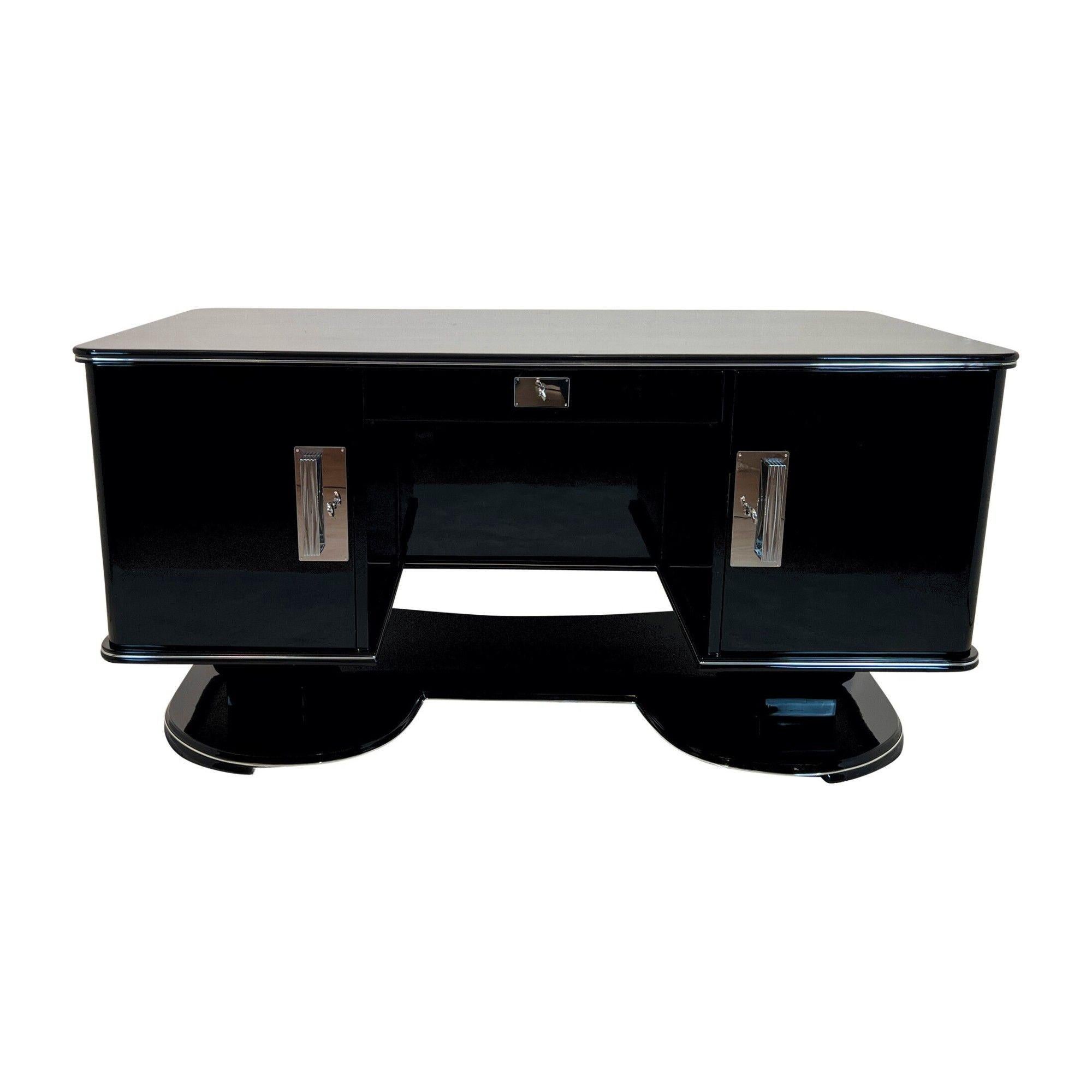 Large Art Deco desk in black lacquer with chrome details from France, 1950s.
High quality restoration with black high gloss polished piano lacquer on mahogany body. Standing on a beautiful large, curved floor base.
Chrome-plated handles and metal