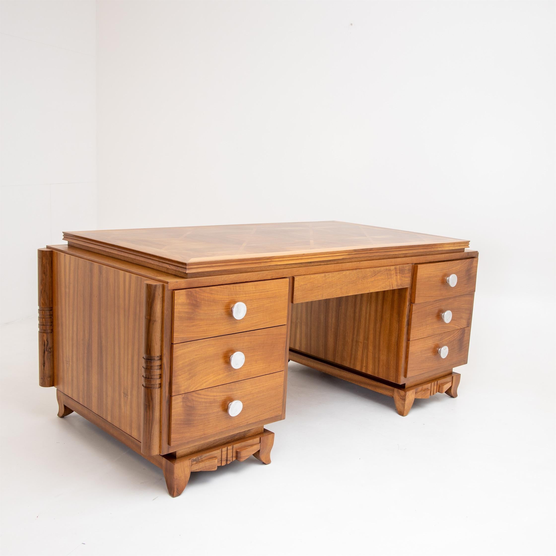 A large Art Deco desk on a finely carved stand with flared short legs and six drawers in the side panels. The corners are rounded, and the desk is veneered on all sides. The desk was professionally restored and hand polished.