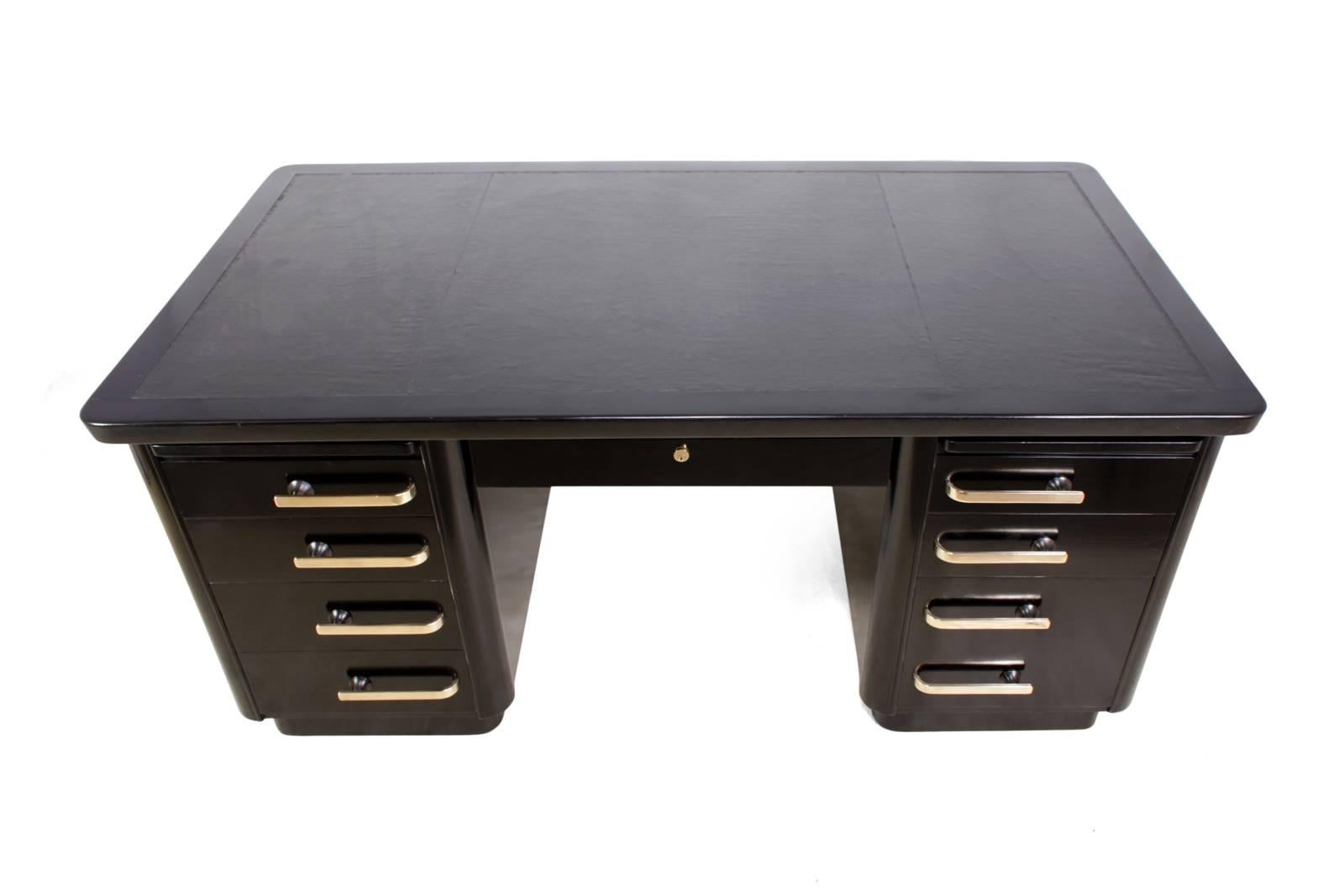 Art Deco desk in black piano lacquer
Produced in the 1950s this desk has a new leather top with polished bronze handles, pen slide at the top, filing drawer to the lower right it has been polished black to a piano type finish, this desk has two