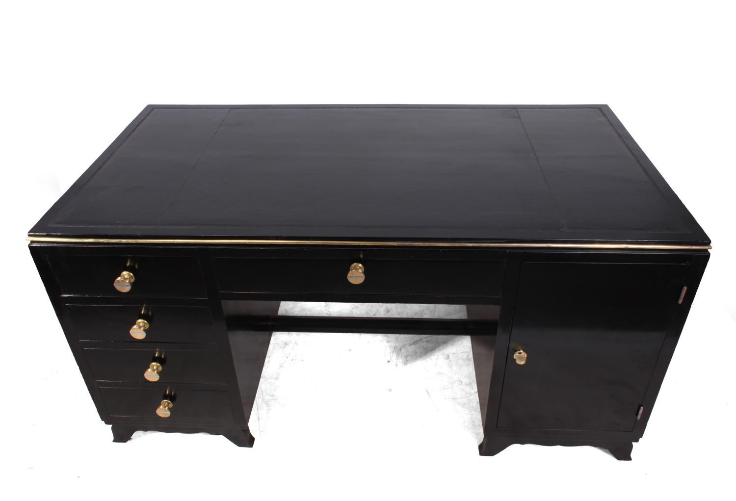 Art Deco desk in black piano lacquer
A twin pedestal Art Deco desk from France circa 1925 having four drawers on the left and cupboard on the right with shelf behind this is lockable and has working key. The Desk has brass handles with inset chrome