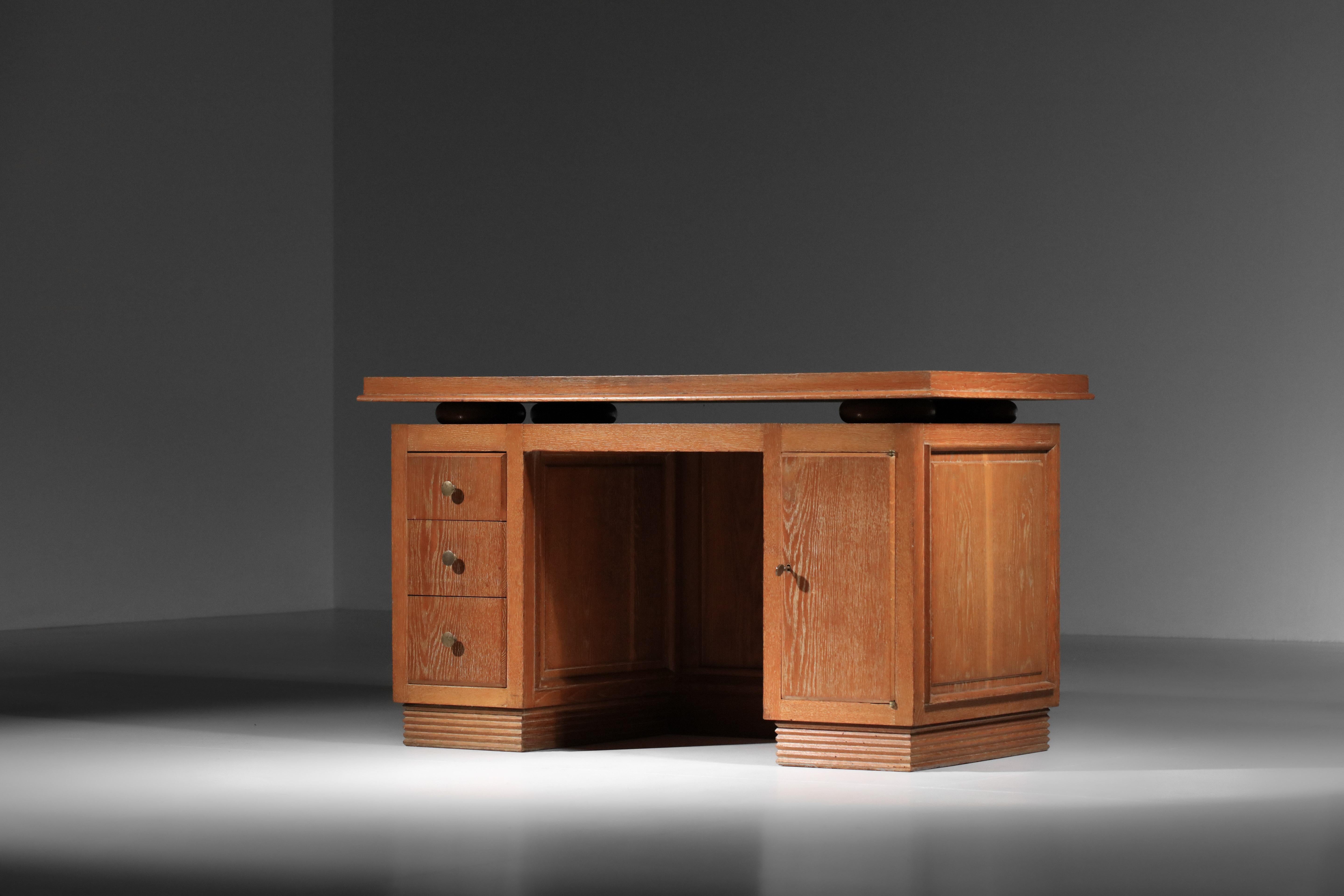 French art deco desk from the 1930s in the style of André Arbus. Solid oak structure with white ceruse finish throughout. It features a column of 3 drawers on the left and a hinged door on the right opening onto a shelf. Very fine manufacturing