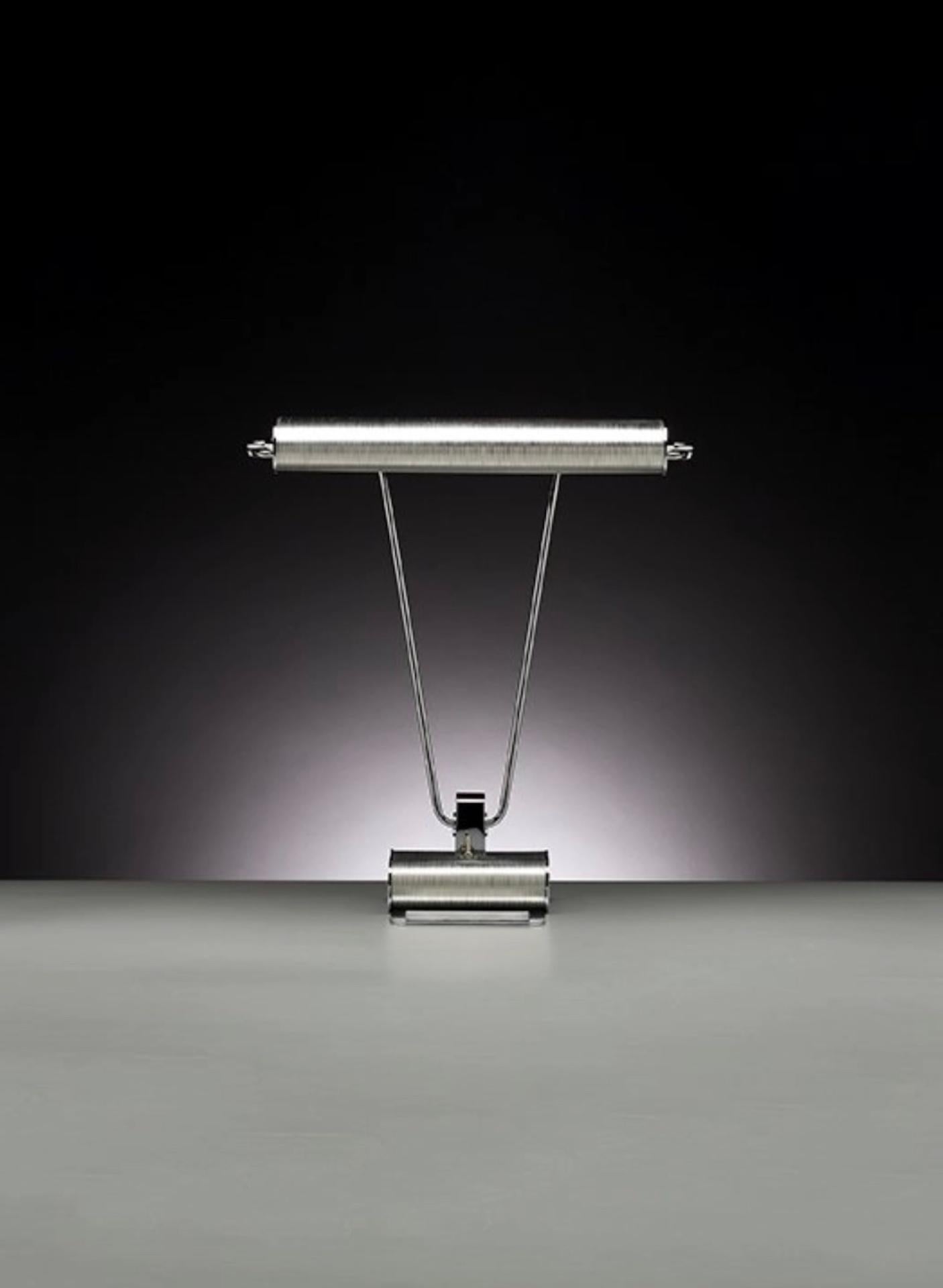 This table lamp has been redesigned based on an Art Deco model from France. Tecnolumen has retained its shape but changed its surface and technical functions. The reflector is rotatable and the linkage adjustable. The metal parts consist of clear