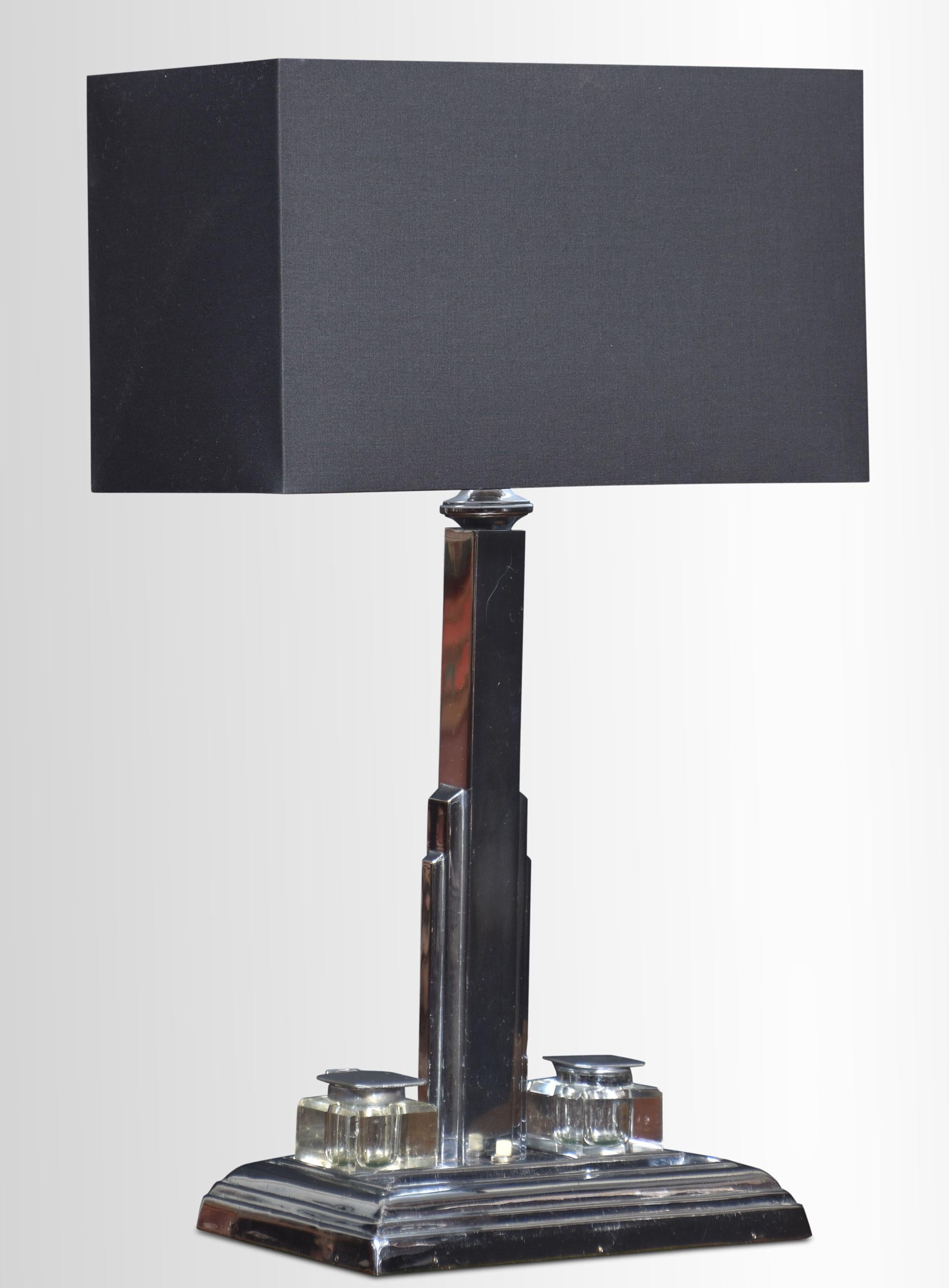 Lampe de bureau Art Déco en chrome, dont la tige carrée est soutenue par une base rectangulaire avec des encriers encastrés et un porte-stylo.
Dimensions
Hauteur 19 pouces
Largeur 11,5 pouces
Profondeur 6 pouces