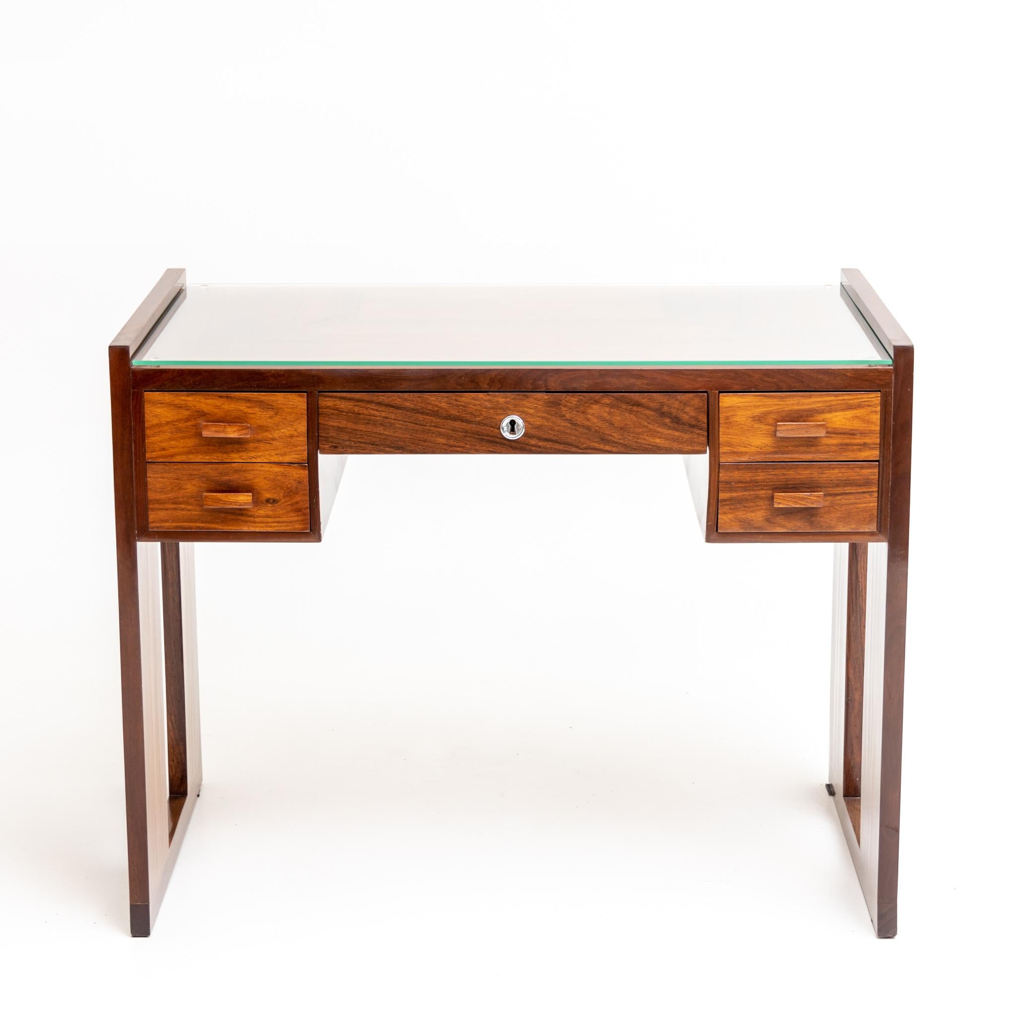 Art Deco desk with five drawers and straight sides with rectangular recess. The top of the desk is protected with a glass top.