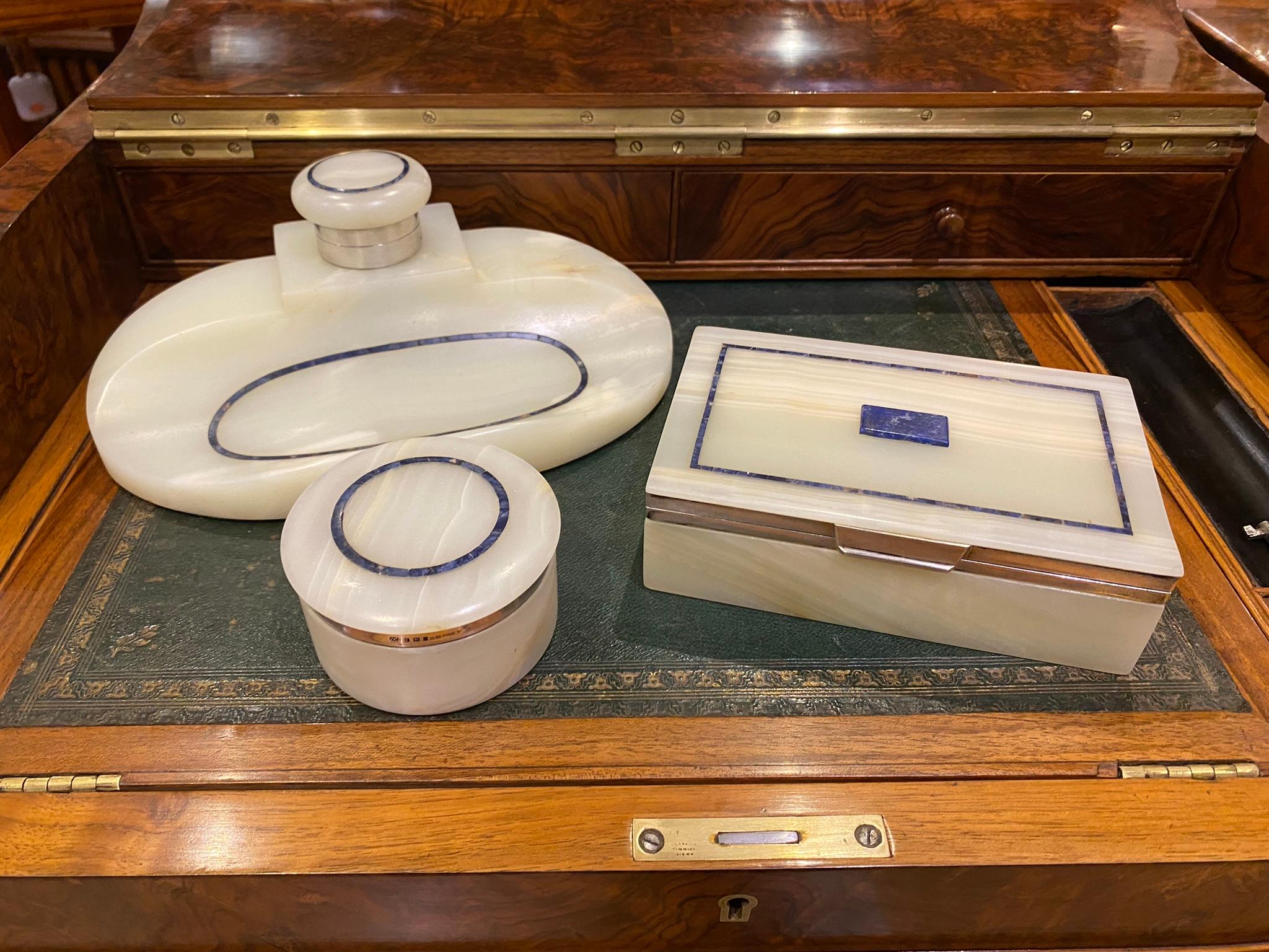 Art Deco Onyx, Lapis & Silver Desk Set, By George Betjemann for Aspreys, London, 1921

This beautiful and rare Onyx and Lapis Lazuli desk set is a luxurious ensemble by George Betjemann & Sons, retailed by Aspreys. Crafted from exquisite onyx,