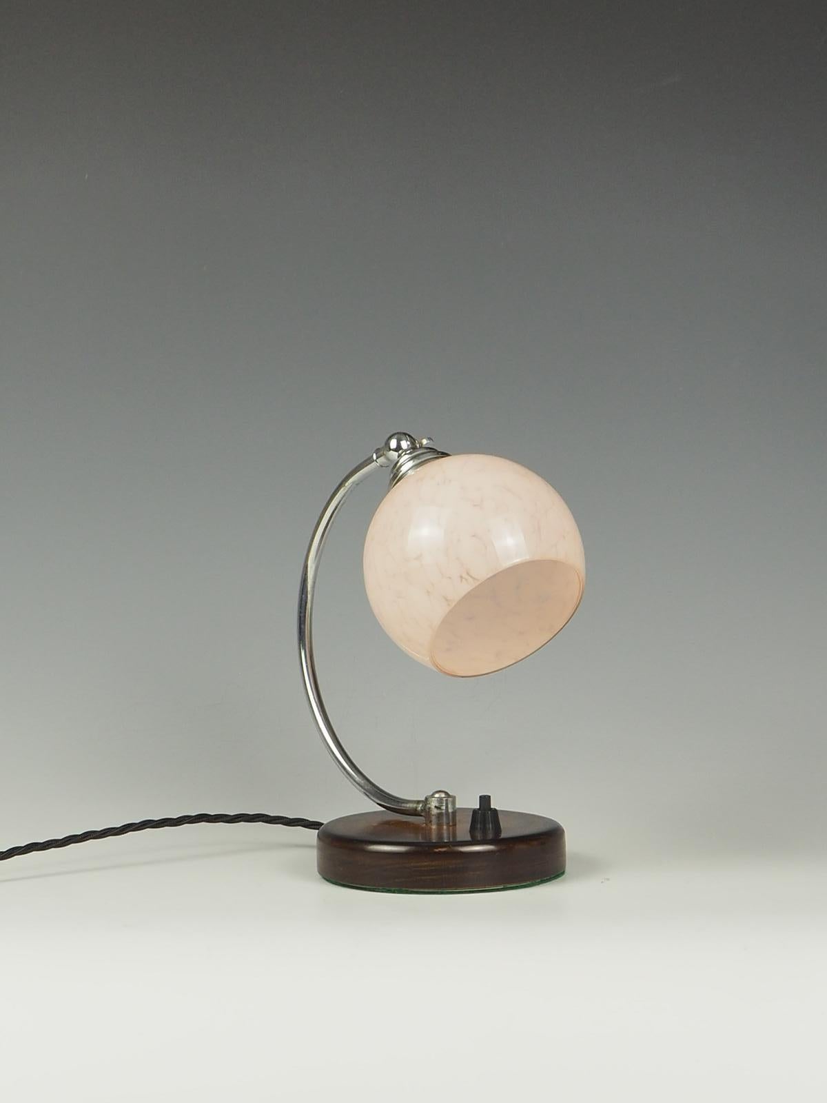 Art Deco Desk Table Lamp with a Pink Globe, a stunning piece that effortlessly combines elegance and functionality. This lamp features a sleek chrome arched arm from a sturdy wooden base, creating a visually appealing contrast. The chrome finish