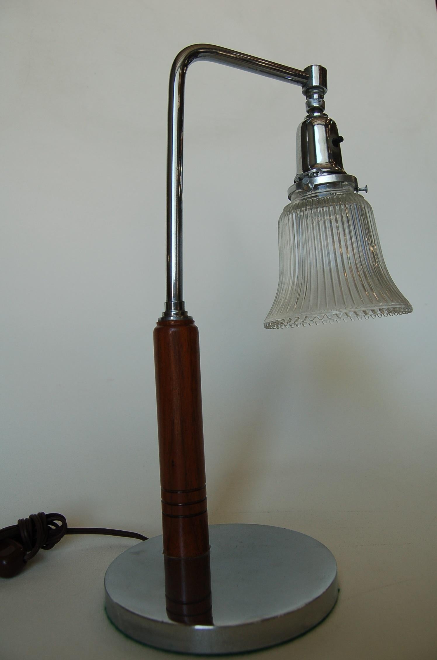 Lampe de bureau Art Déco avec abat-jour en verre en forme de cloche et garniture en bois et chrome.

Mesures : 9