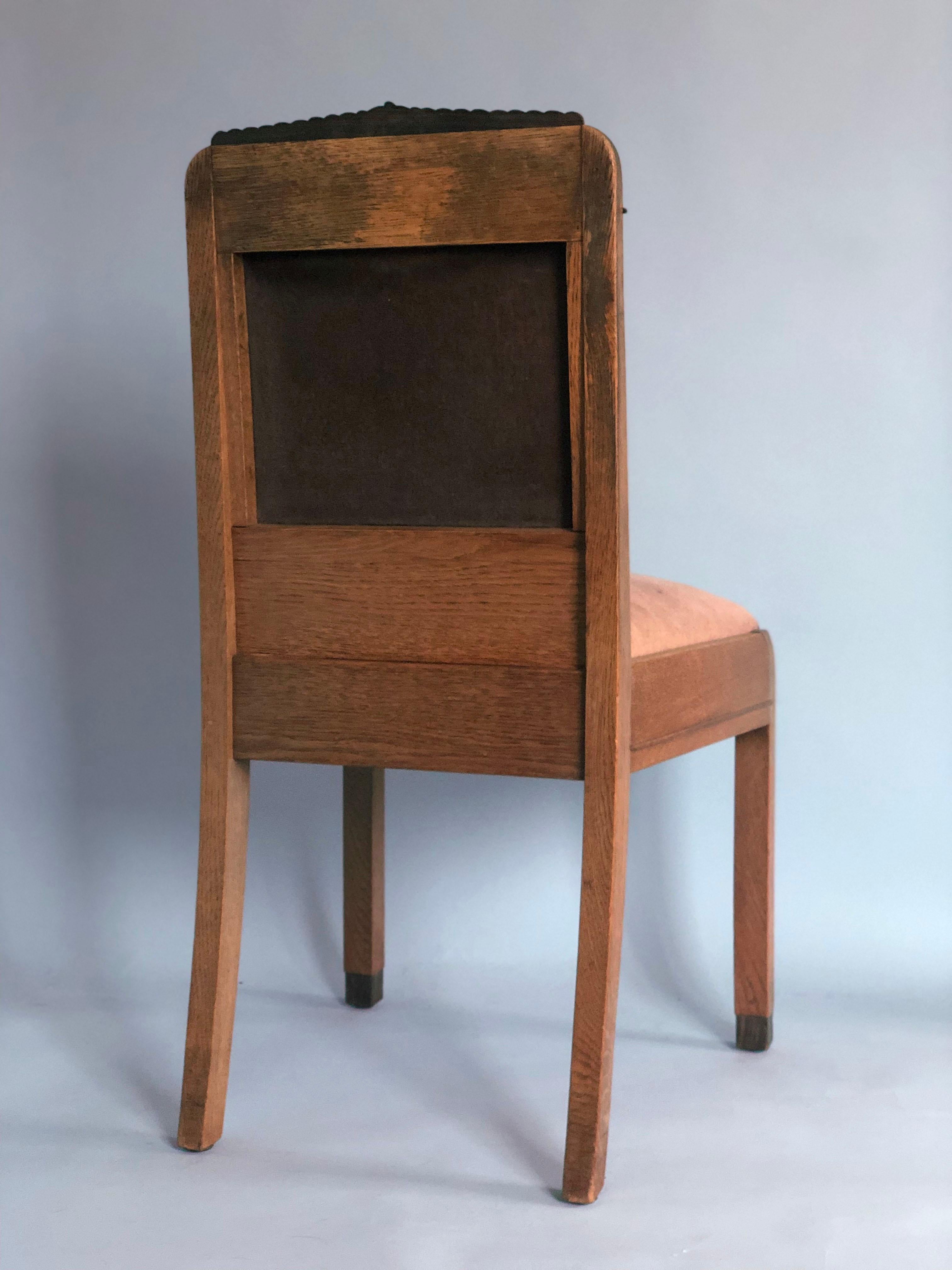 A richly detailed oak Amsterdam School chair from the early 1920s, the Netherlands. A chic look from the Art Deco period with slightly curved oak sides. This chair has a coromandel ornament at the top and accents on the side and on 2 legs at the
