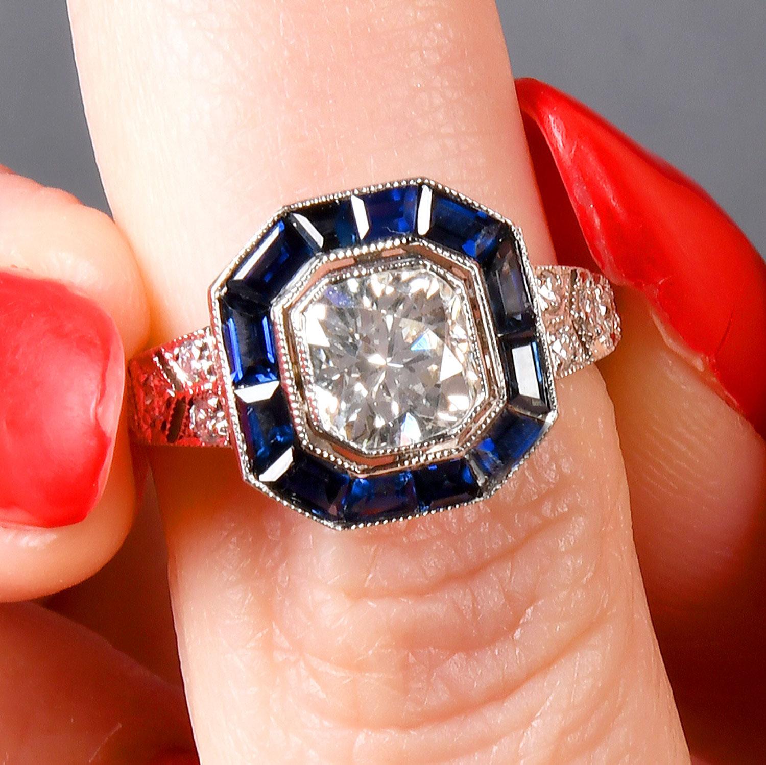 Stunning Art Deco design Engagement Ring, featuring a mesmerizing 1.00-carat old mine cushion cut natural diamond at its heart.

This central Square Cushuiondiamond, boasting a VS2-SI1 clarity and H-I in color, is brilliantly framed by a halo of